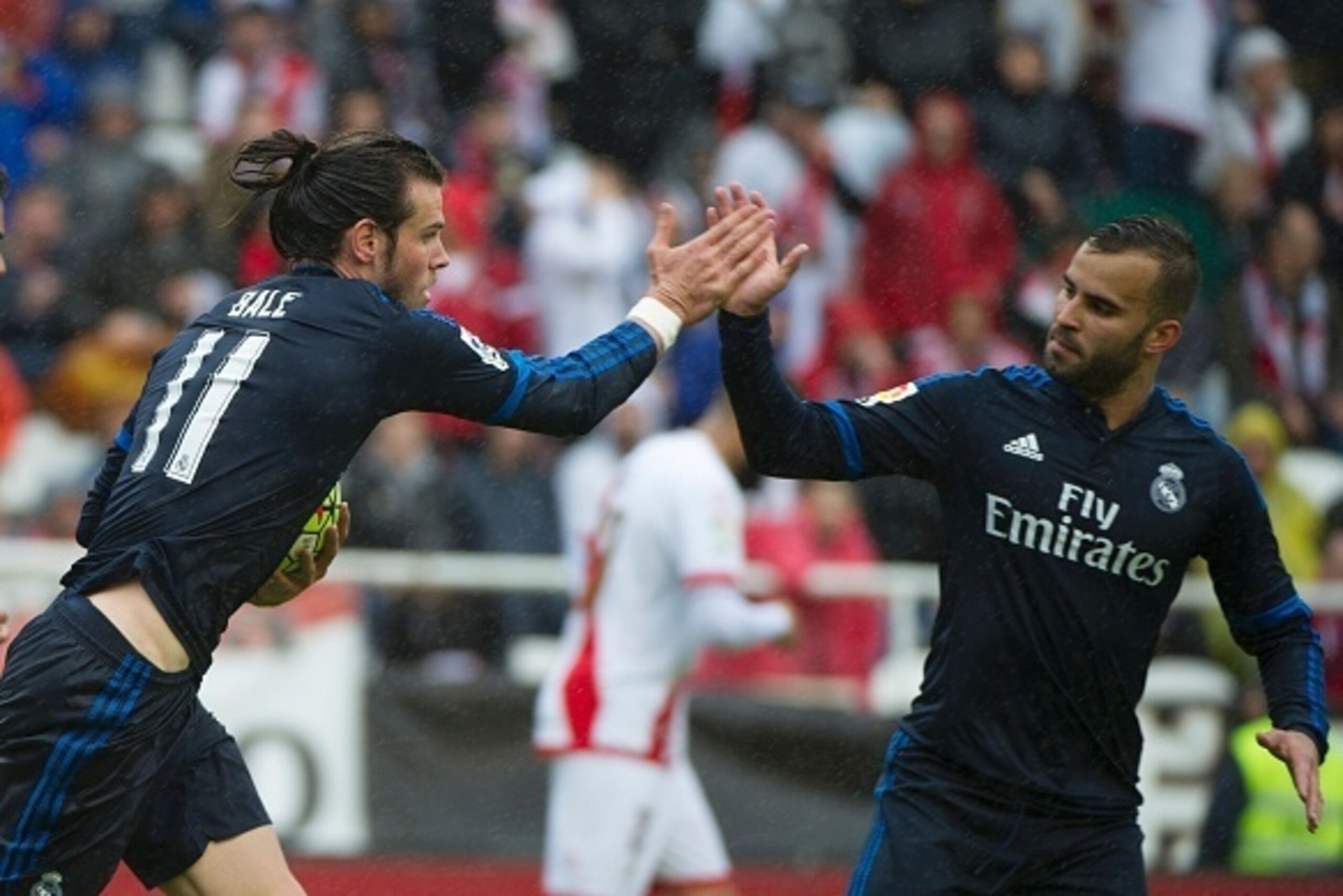 Real Madrid's Welsh forward Gareth Bale (L) celebrates after scoring with Real Madrid's forward Jese Rodriguez during the Spanish league football match Rayo Vallecano de Madrid vs Real Madrid CF at the Vallecas stadium in Madrid on April 23, 2016. / AFP /