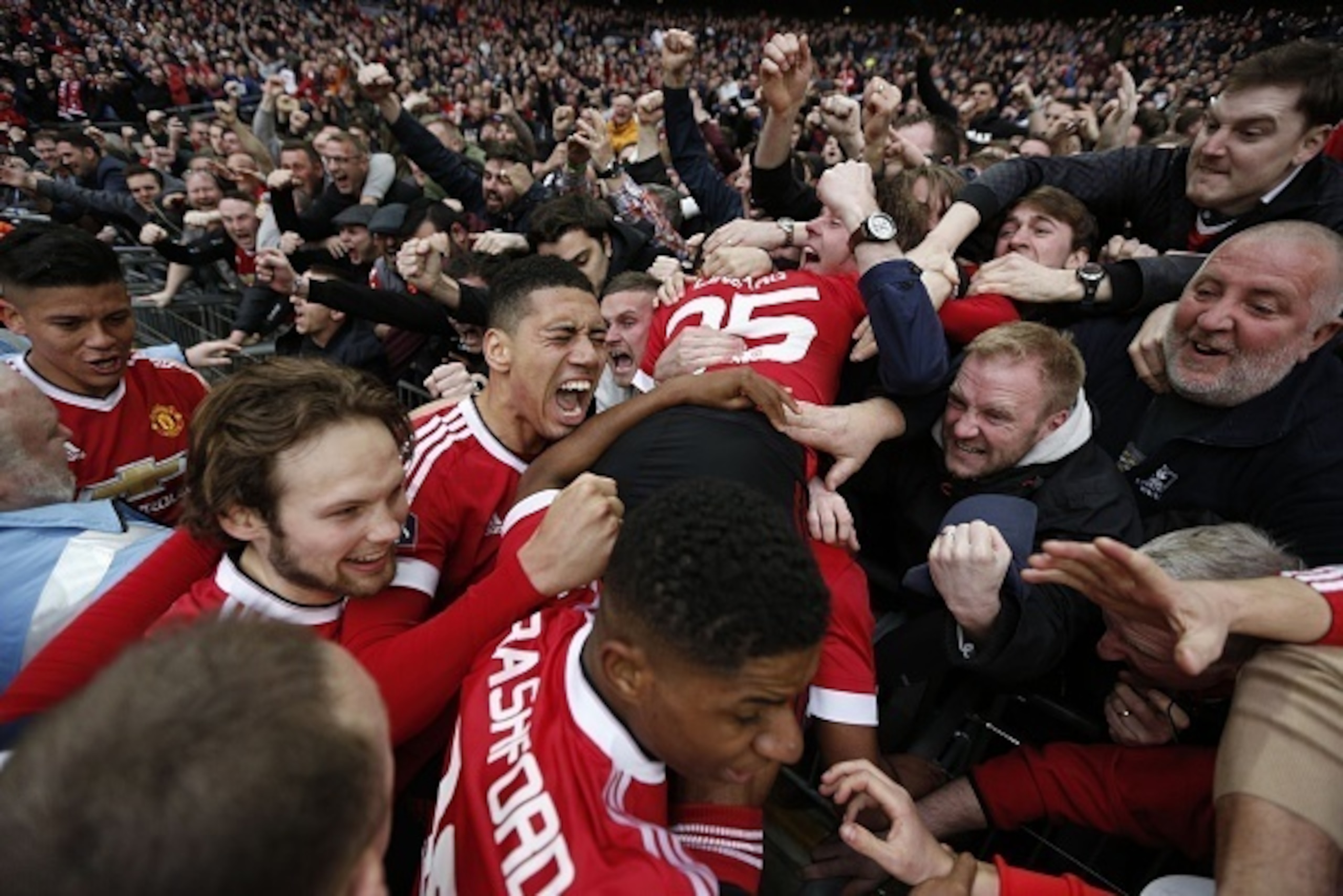 Manchester United players celebrate with the crowd including Manchester United's English midfielder Jesse Lingard (R), Manchester United's English defender Chris Smalling (3L), Manchester United's Dutch midfielder Daley Blind (2L), Manchester United's Arg