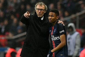 Paris Saint-Germain's French head coach Laurent Blanc (L) speaks with midfielder Christopher Nkunku during the French L1 football match between Paris Saint-Germain and Nice at the Parc des Princes stadium in Paris on April 2, 2016.   / AFP / FRANCK FIFE  