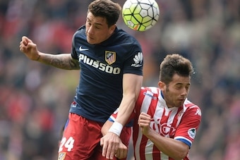 Atletico Madrid's Uruguayan defender Jose Maria Gimenez (L) heads the ball with Sporting Gijon's midfielder Jony during the Spanish league football match Real Sporting de Gijon vs Club Atletico de Madrid at El Molinon stadium in Gijon on March 19, 2016. /
