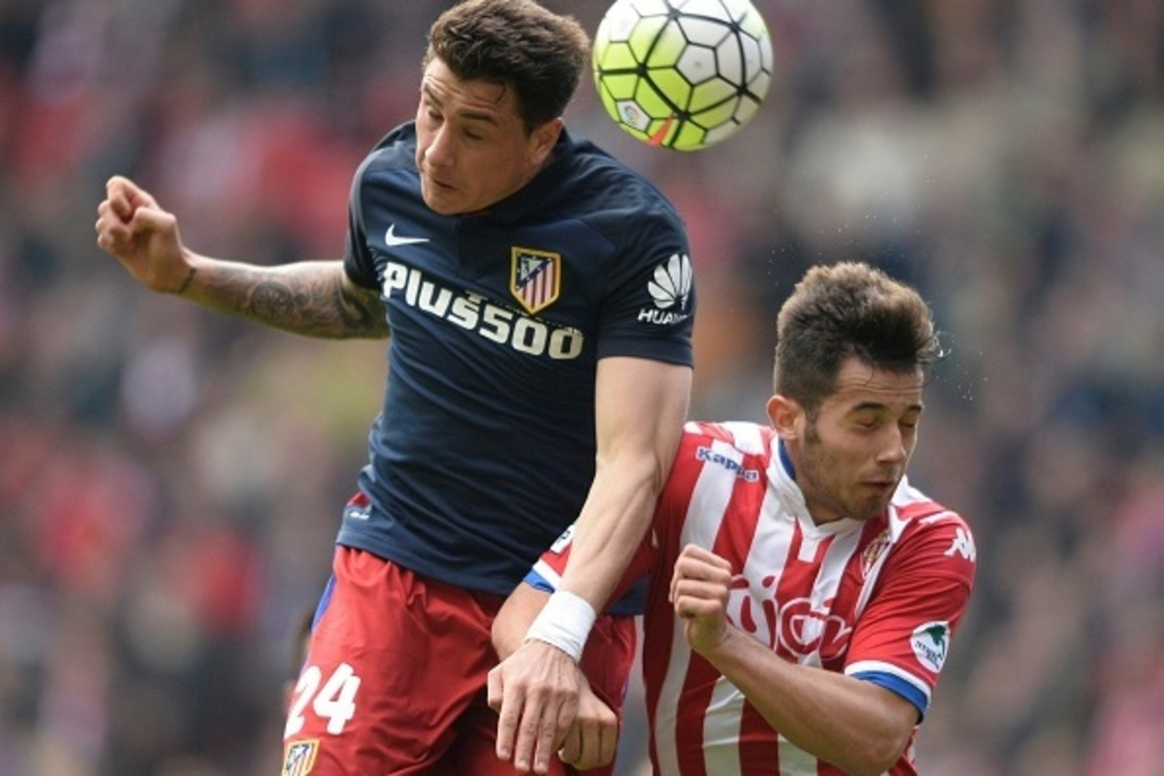 Atletico Madrid's Uruguayan defender Jose Maria Gimenez (L) heads the ball with Sporting Gijon's midfielder Jony during the Spanish league football match Real Sporting de Gijon vs Club Atletico de Madrid at El Molinon stadium in Gijon on March 19, 2016. /