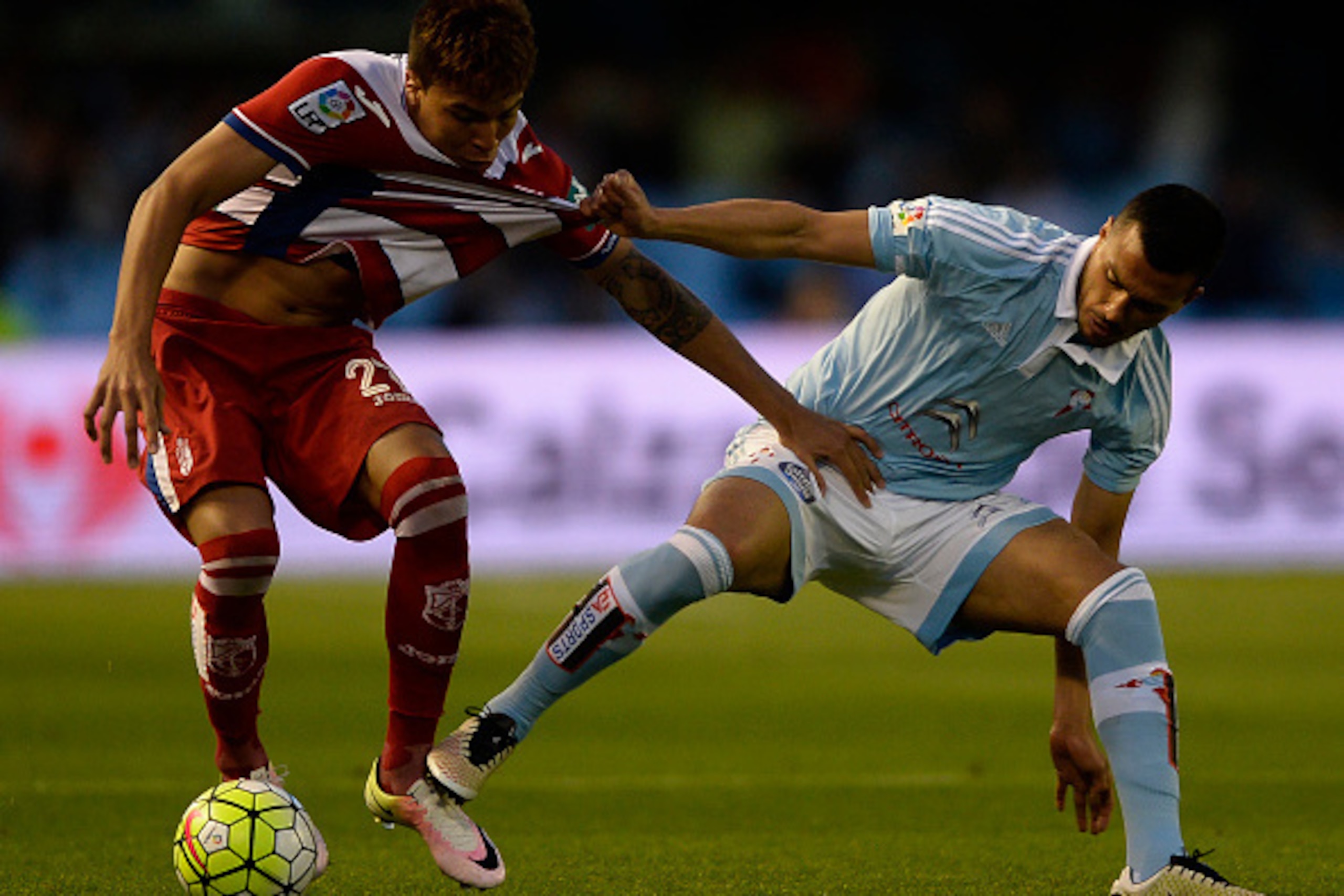 Celta Vigo's Argentinian defender Gustavo Cabral (R) vies with Granada's Venezuelan forward Adalberto Penaranda during the Spanish league football match RC Celta de Vigo vs Granada FC at the Balaidos stadium in Vigo on April 25, 2016. Celta won the match 