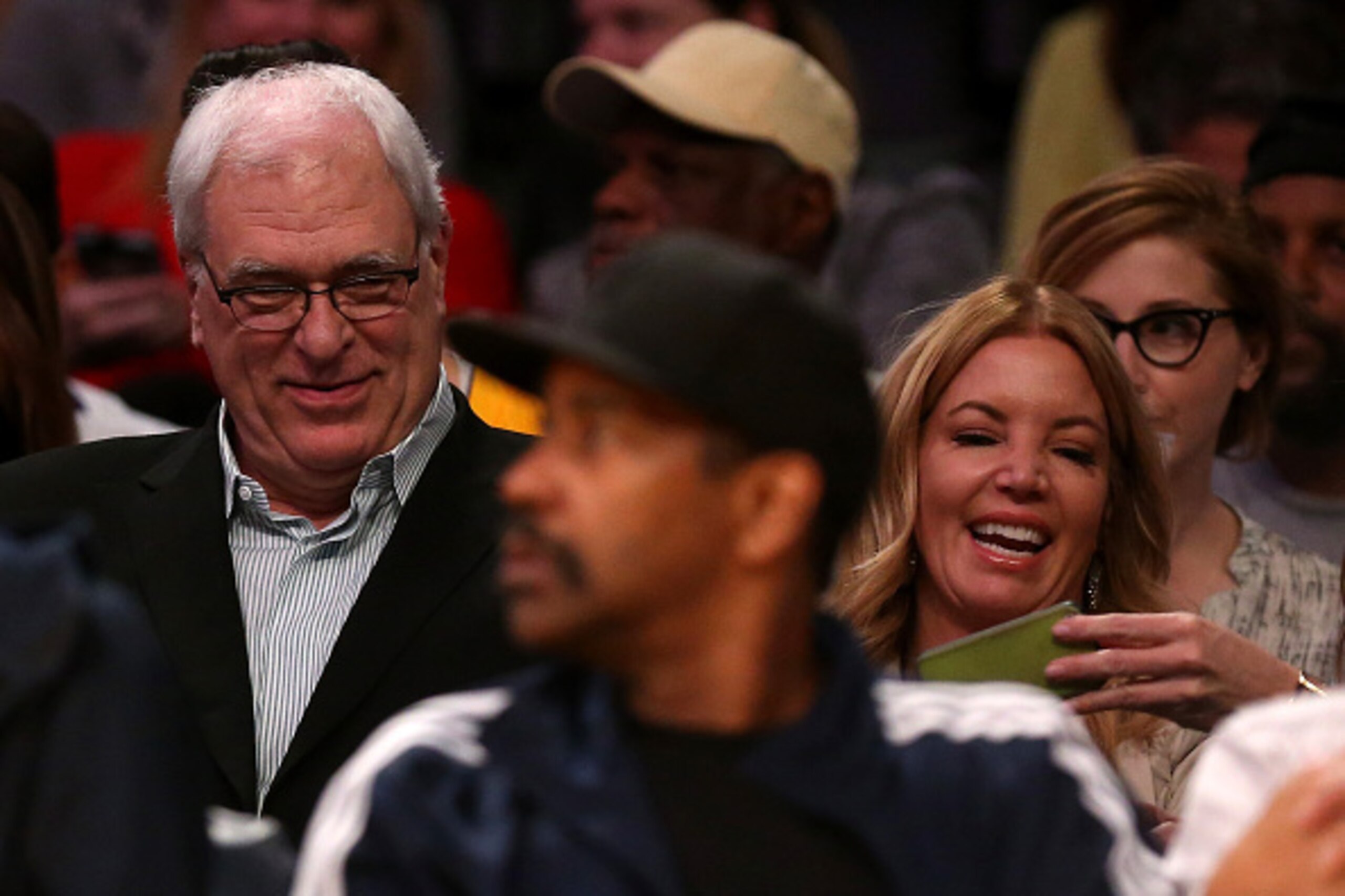 LOS ANGELES, CA - MARCH 12:  Phil Jackson, president of the New York Knicks, sits with Jeanie Buss, part-owner and president the Los Angeles Lakers, at Staples Center on March 12, 2015 in Los Angeles, California. Actor Denzel Washington is in the foregrou