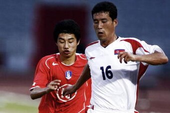 MACAU, CHINA:  Nam Song Chol (R) of North Korean kicks the ball ahead of Chun Je Hun of South Korea during the men's football semi final at the 4th East Asian Games in Macau, 05 November 2005.  North Korea won 2-0.   AFP PHOTO/Antony Dickson  (Photo credi