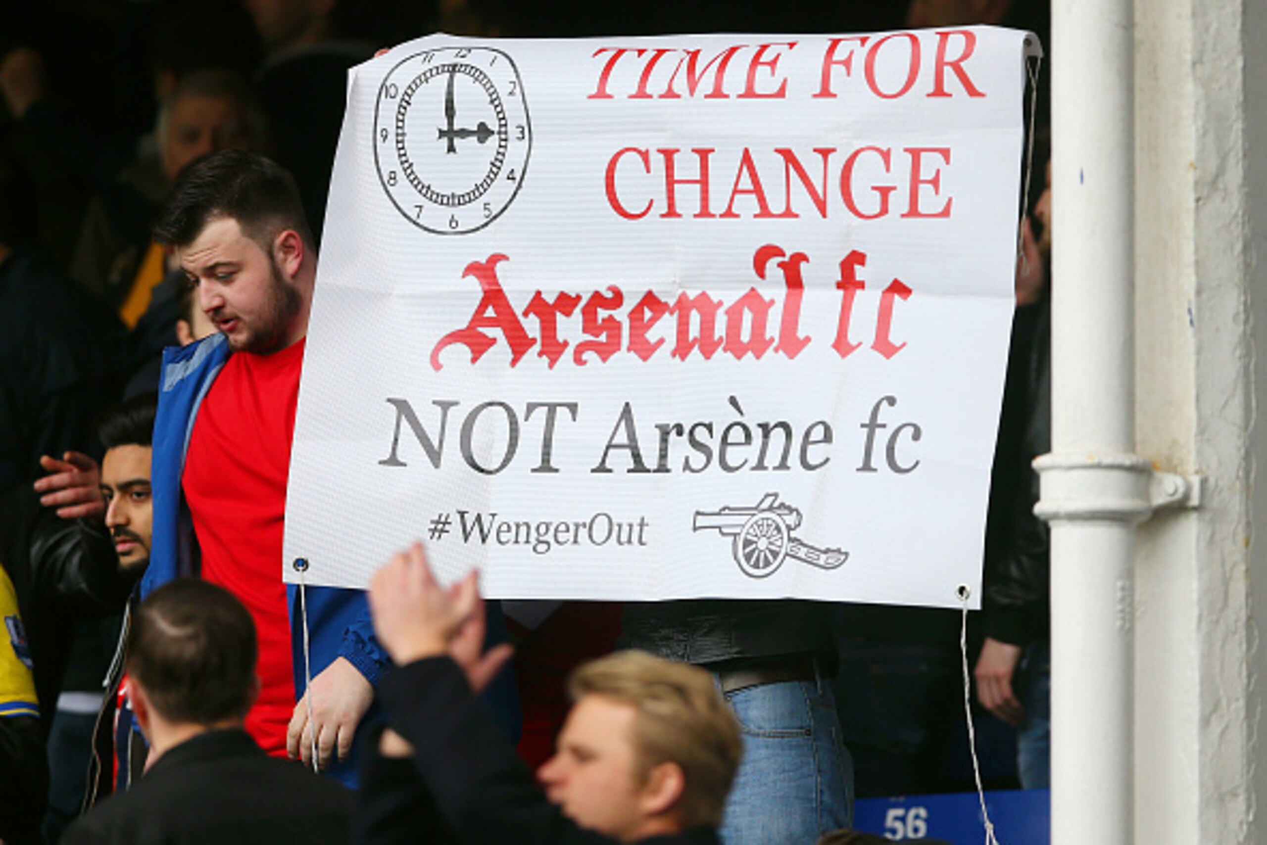 LIVERPOOL, ENGLAND - MARCH 19:  Arsenal supporter holds a banner asking to replace manager Arsene Wenger after the Barclays Premier League match between Everton and Arsenal at Goodison Park on March 19, 2016 in Liverpool, England.  (Photo by Ian MacNicol/
