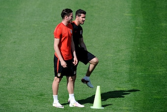 MADRID, SPAIN - APRIL 26:  Diego Simeone, Manager of Atletico Madrid (r) talks to Saul Niguez of Atletico Madrid during a training session ahead of the UEFA Champions League Semi-Final First Leg between Club Atletico de Madrid and Bayern Meunchen at Majad