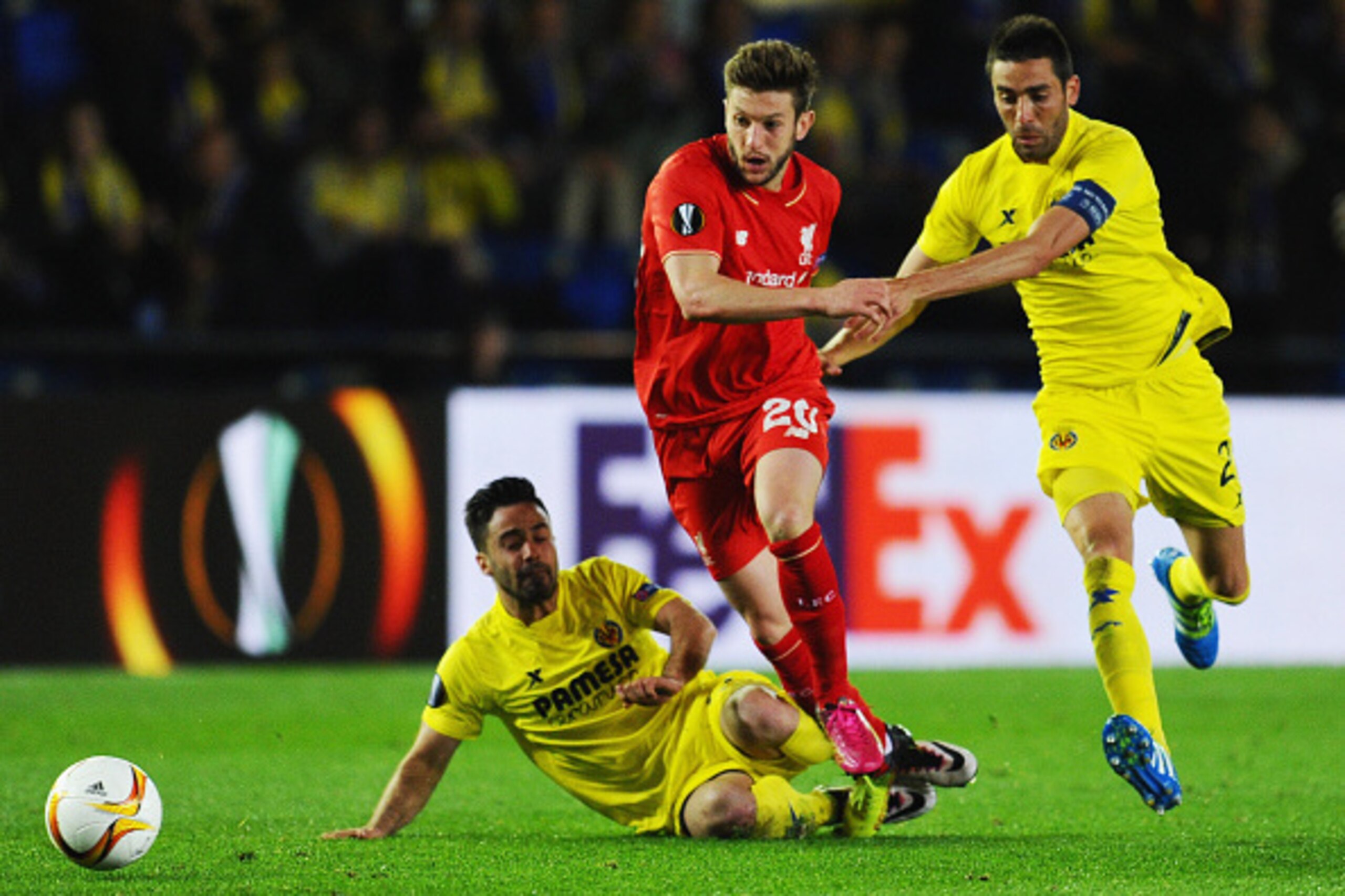 VILLARREAL, SPAIN - APRIL 28:  Adam Lallana of Liverpool takes on Jaume (L) and Bruno of Villarreal (R) during the UEFA Europa League semi final first leg match between Villarreal CF and Liverpool at Estadio El Madrigal on April 28, 2016 in Villarreal, Sp