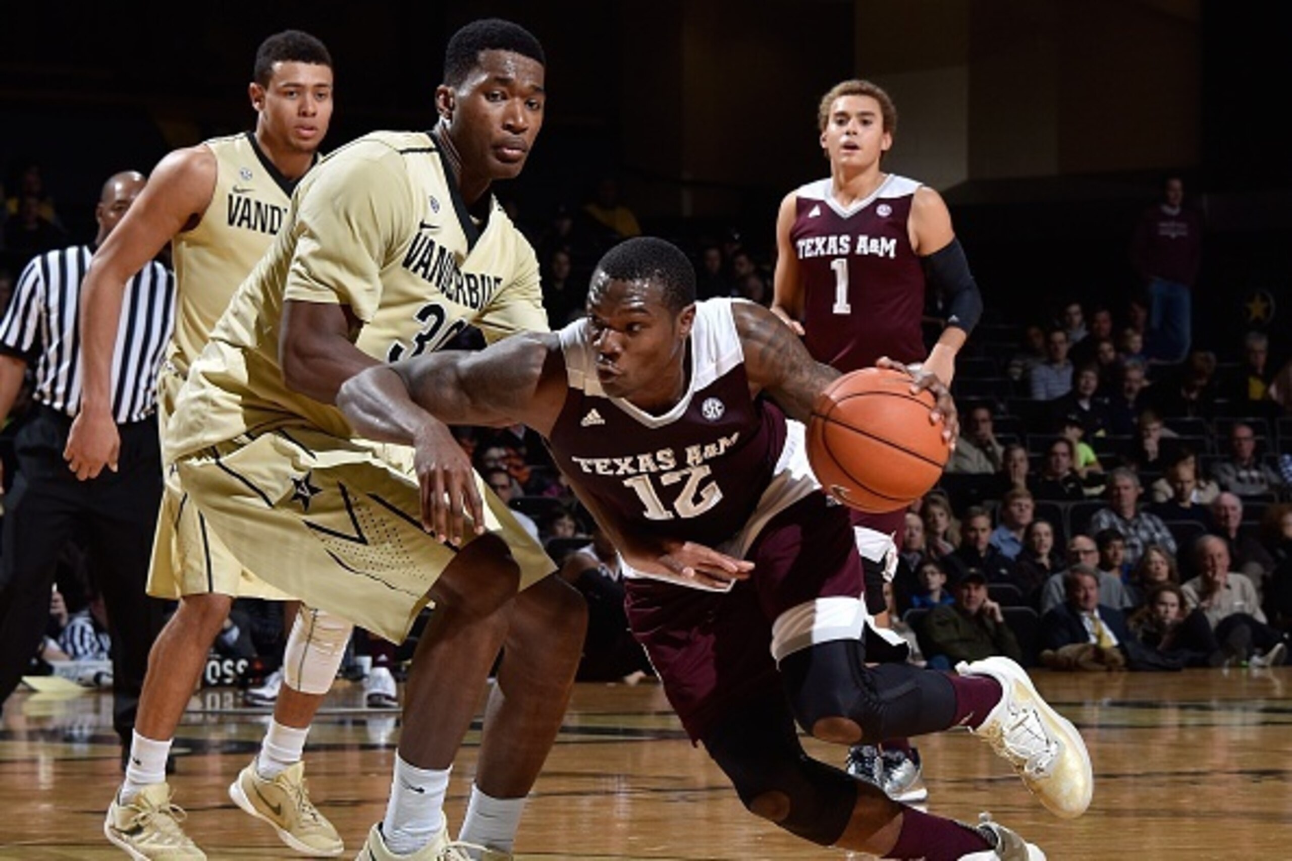 NASHVILLE, TENNESSEE - FEBRUARY 04:  Jalen Jones #12 of the Texas A&M Aggies drives into Damian Jones #30 of the Vanderbilt Commodores  during the first half at Memorial Gym on February 4, 2016 in Nashville, Tennessee.  (Photo by Frederick Breedon/Getty I