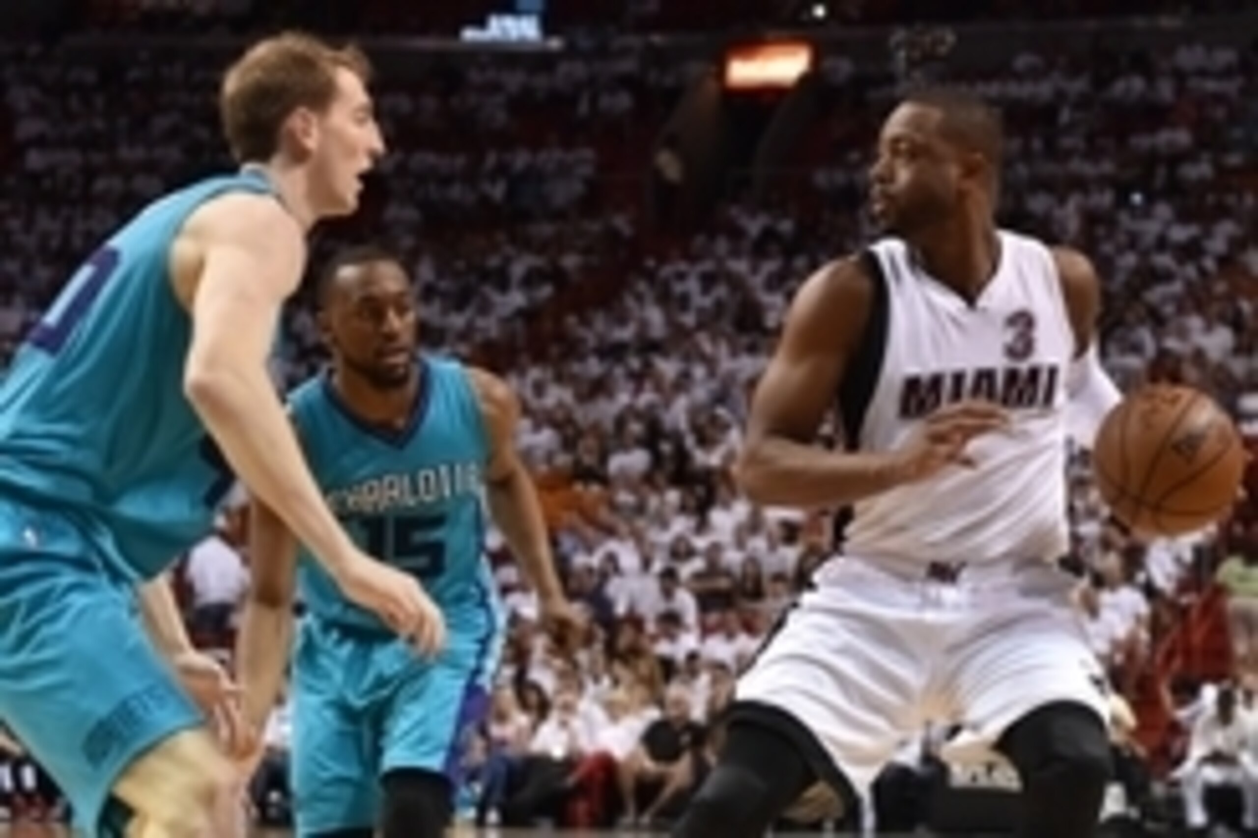 Apr 17, 2016; Miami, FL, USA; Miami Heat guard Dwyane Wade (3) dribbles the ball as Charlotte Hornets guard Kemba Walker (15) and center Cody Zeller (L) defend during the second half in game one of the first round of the NBA Playoffs at American Airlines 