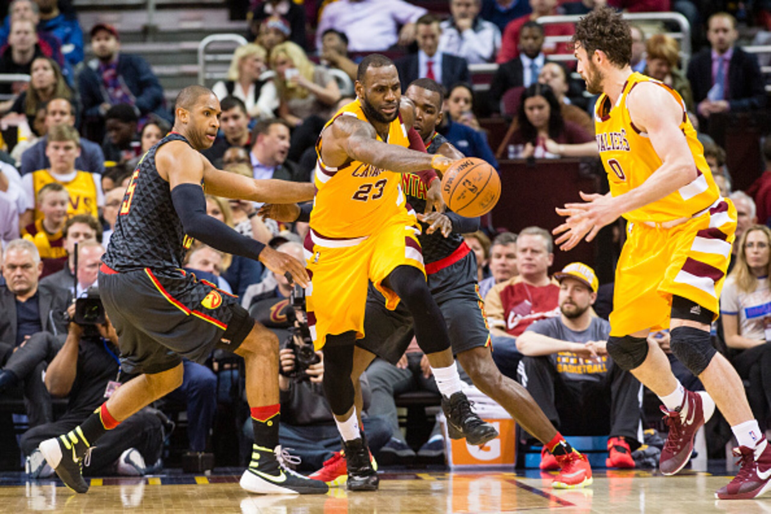 CLEVELAND, OH - APRIL 11: Al Horford #15 and Paul Millsap #4 of the Atlanta Hawks put pressure on LeBron James #23 as James passes to Kevin Love #0 of the Cleveland Cavaliers during the second half at Quicken Loans Arena on April 11, 2016 in Cleveland, Oh
