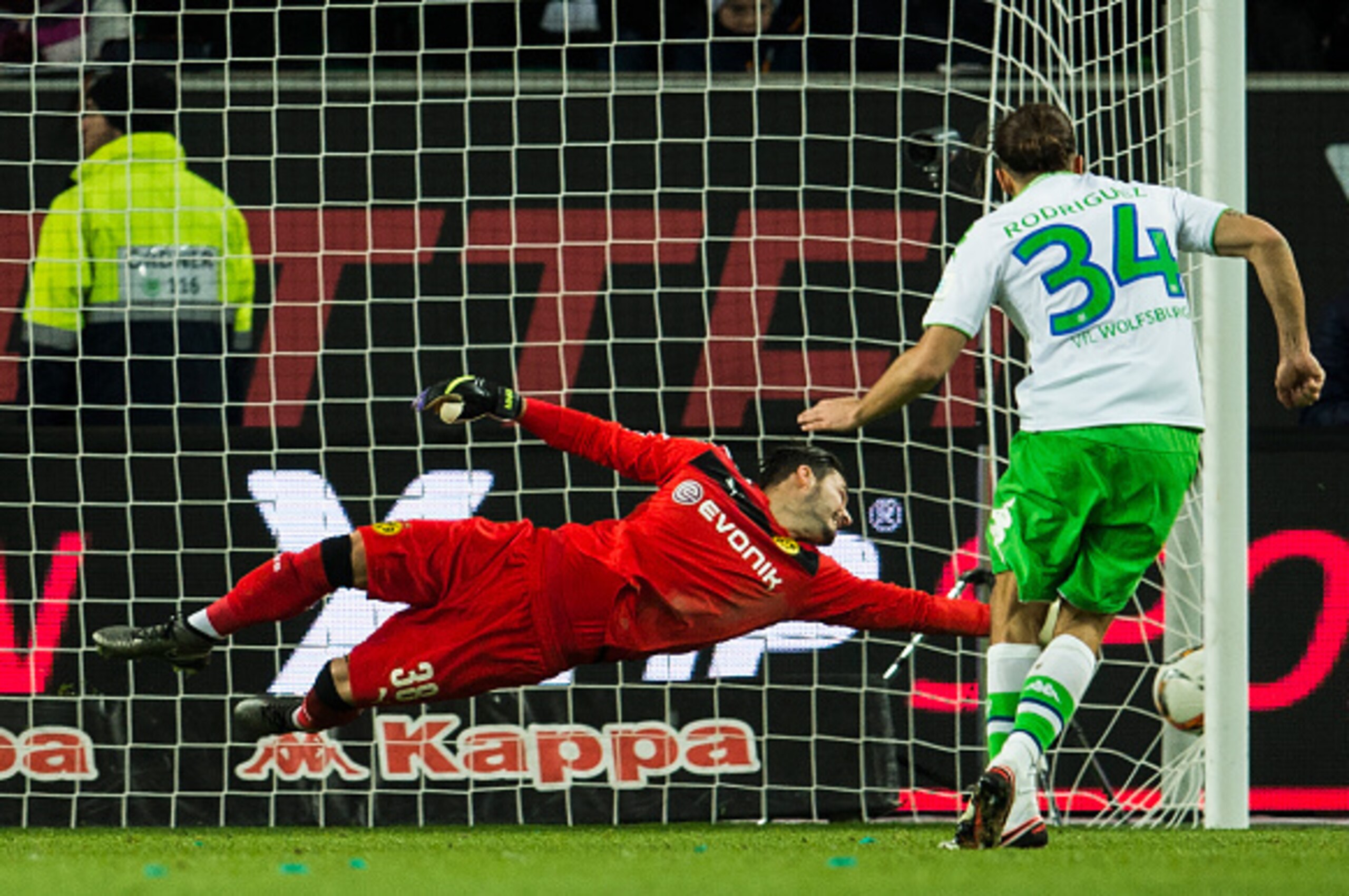 Dortmund's Swiss goalkeeper Roman Burki (L) fails to save a penalty kick from Wolfsburg's Swiss defender Ricardo Rodriguez during the German first division Bundesliga football match Wolfsburg vs Dortmund in Wolfsburg on December 5, 2015.  
AFP PHOTO / ODD