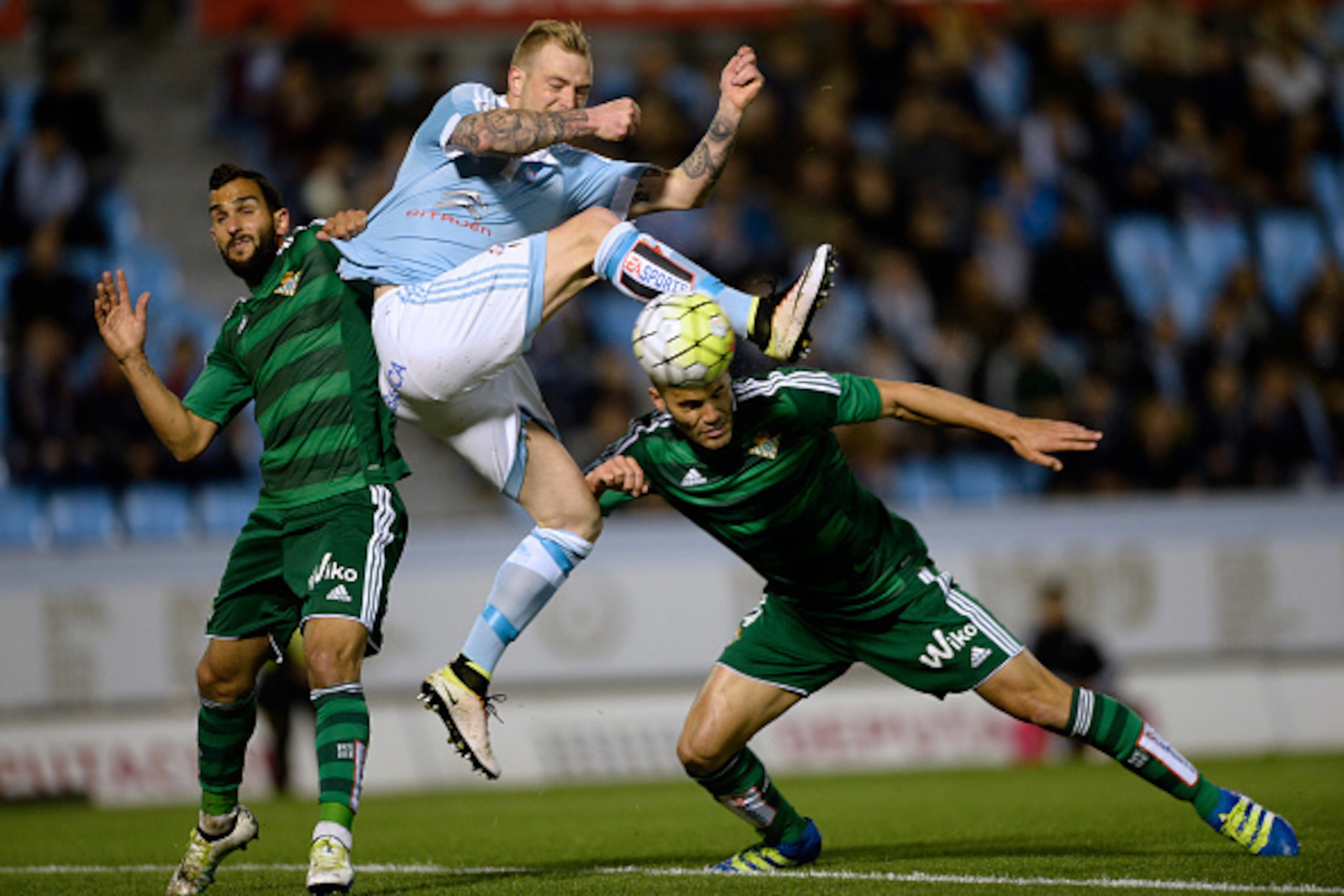 Celta Vigo's Swedish forward John Guidetti (C) vies with Betis' defender Martin Montoya (L) and defender Bruno Gonzalez during the Spanish league football match RC Celta de Vigo vs Real Betis at the Balaidos stadium in Vigo on April 16, 2016. / AFP / MIGU