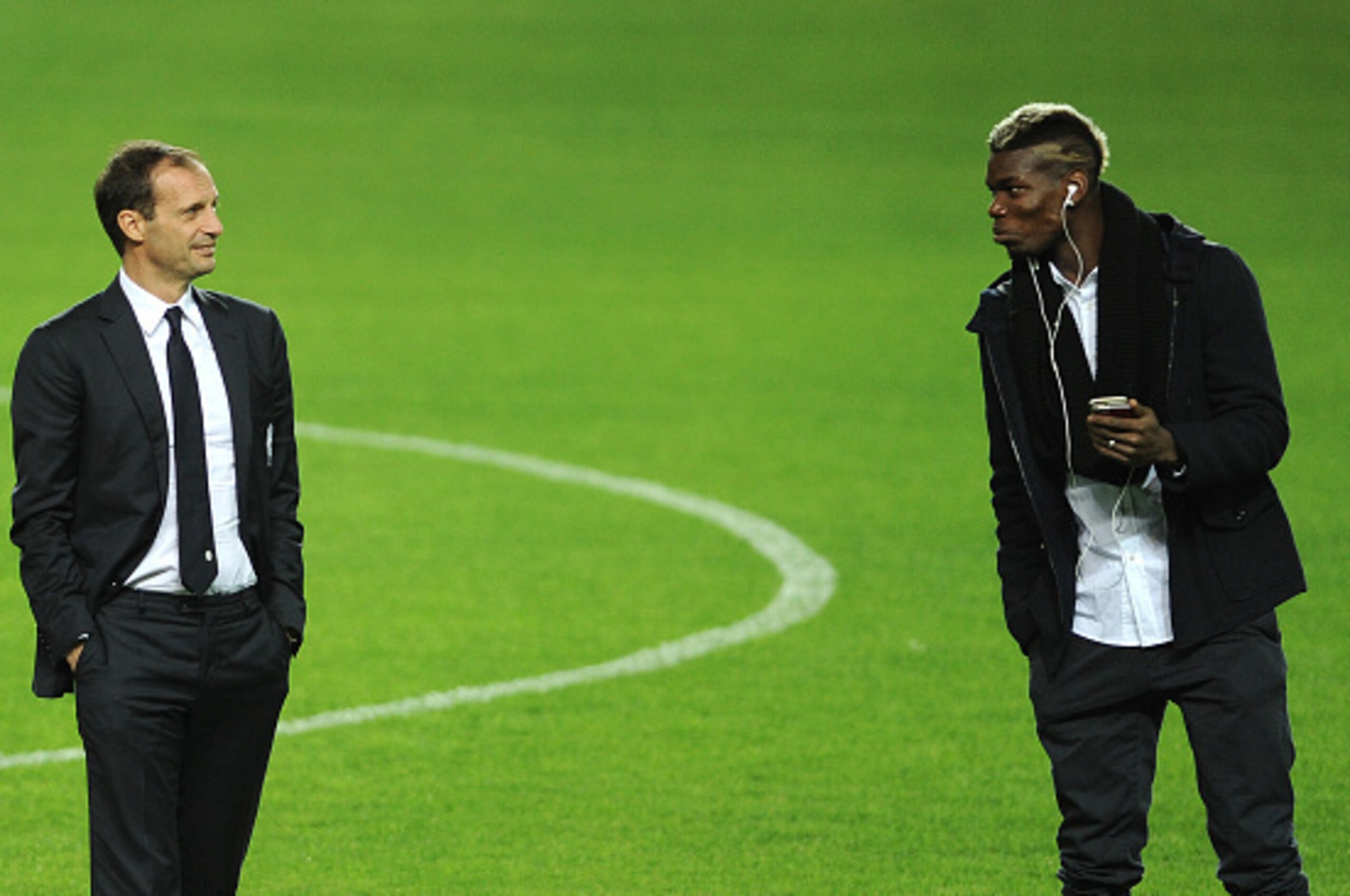 Juventus's French midfielder Paul Pogba (R) speaks with Juventus's coach Italian Massimiliano Allegri (L) at the Ramon Sanchez Pizjuan in Sevilla on December 7, 2015, on the eve of the UEFA Champions League Group D football match Sevilla FC vs Juventus.  