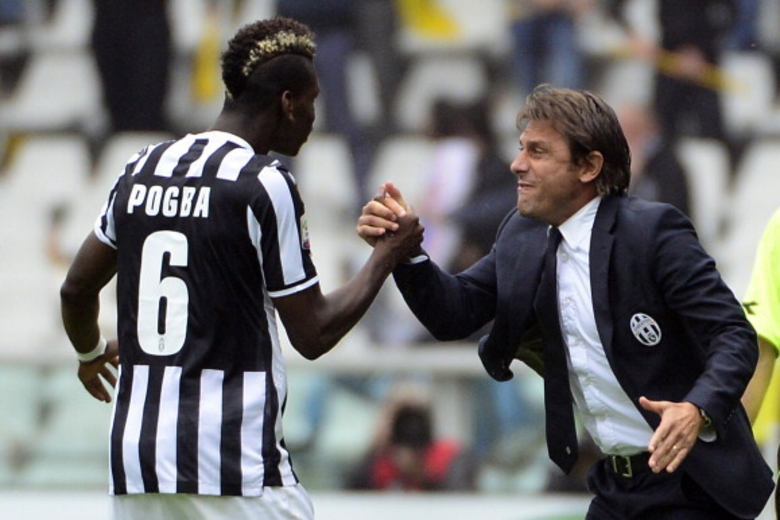 Juventus' French midfielder Paul Labile Pogba (L) celebrates with coach Antonio Conte after scoring during the Serie A football match Torino vs Juventus at the Olimpico stadium on September 29, 2013 in Turin. AFP PHOTO / OLIVIER MORIN        (Photo credit