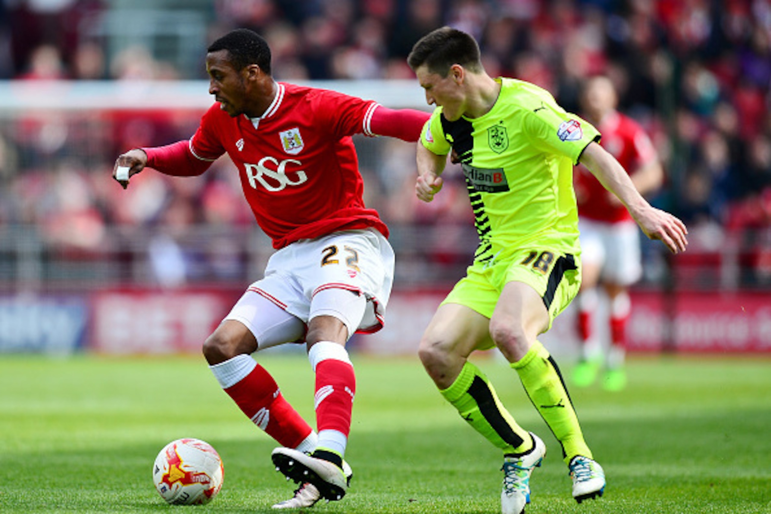 BRISTOL, ENGLAND - APRIL 30:  Jonathan Kodjia of Bristol City holds off Joe Lolley of Huddersfield Town during the Sky Bet Championship match between Bristol City and Huddersfield Town at Ashton Gate on April 30, 2016 in Bristol, England.  (Photo by Dan M