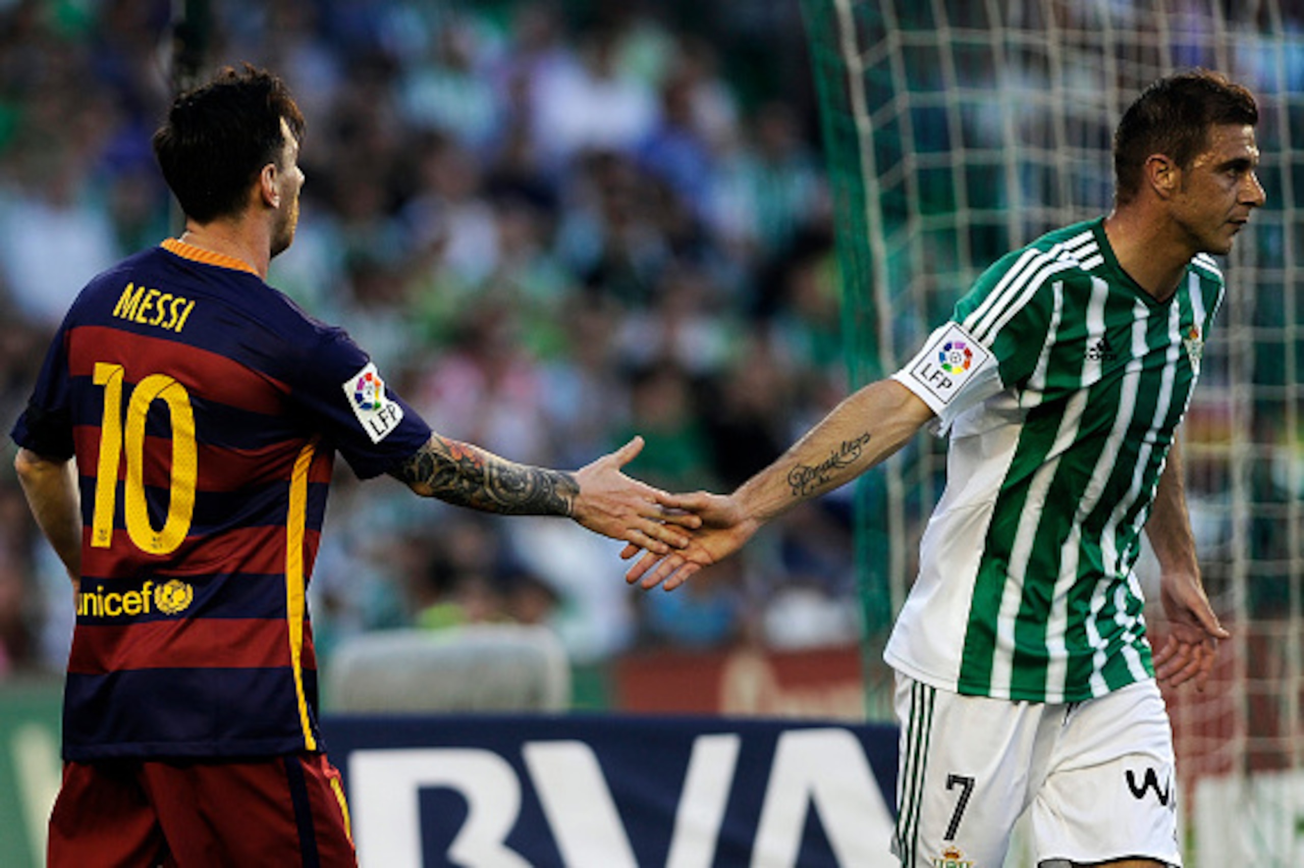 Barcelona's Argentinian forward Lionel Messi (L) shakes hands Betis' forward Joaquin (R) during the Spanish league football match Real Betis Balompie vs FC Barcelona at the Benito Villamarin stadium in Sevilla on April 30, 2016. / AFP / CRISTINA QUICLER  