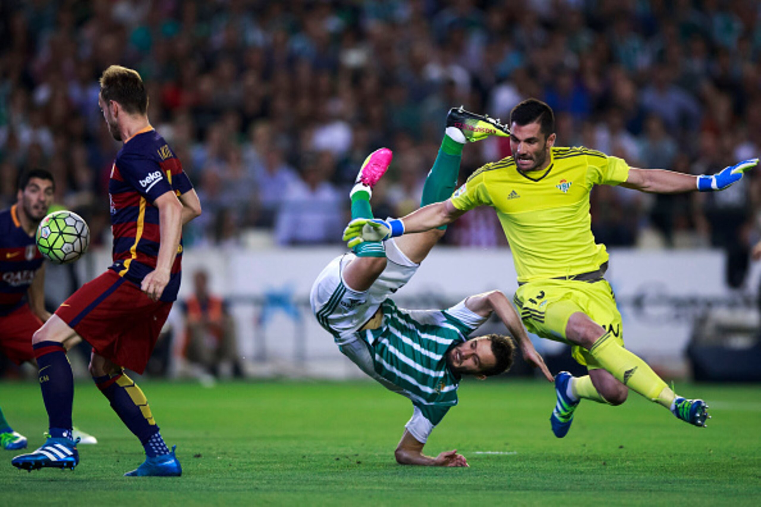 SEVILLE, SPAIN - APRIL 30: Ivan Rakitic (L) of FC Barcelona passes goalkeeper Antonio Adan (R) of Real Betis Balompie and his teammate German Pezzella (2ndR) prior to score his opening goal during the La Liga match between Real Betis Balompie and FC Barce