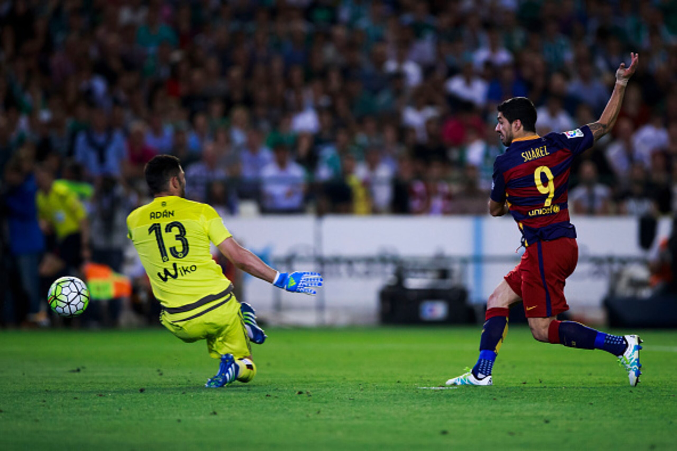 SEVILLE, SPAIN - APRIL 30: Luis Suarez (R) of FC Barcelona scores their second goal against goalkeeper Antonio Adan (L) of Real Betis Balompie during the La Liga match between Real Betis Balompie and FC Barcelona at Estadio Benito Villamarin on April 30, 