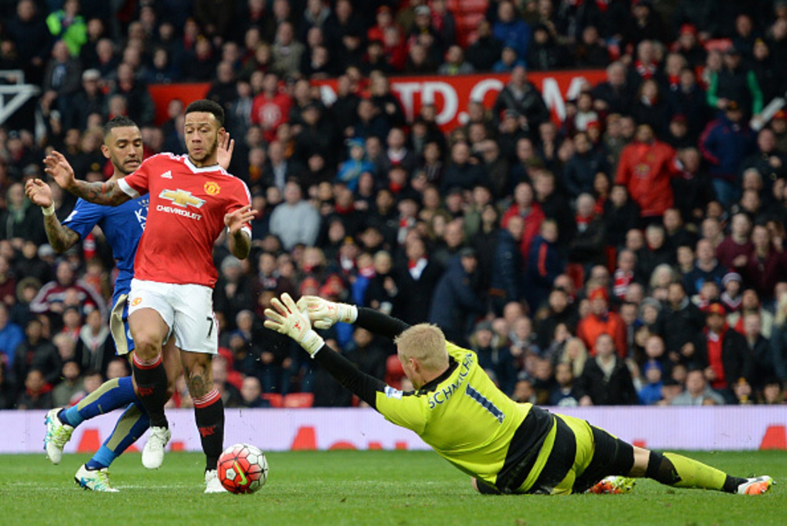 Leicester City's Danish goalkeeper Kasper Schmeichel (R) comes out to make a save from Manchester United's Dutch midfielder Memphis Depay (C) during the English Premier League football match between Manchester United and Leicester City at Old Trafford in 