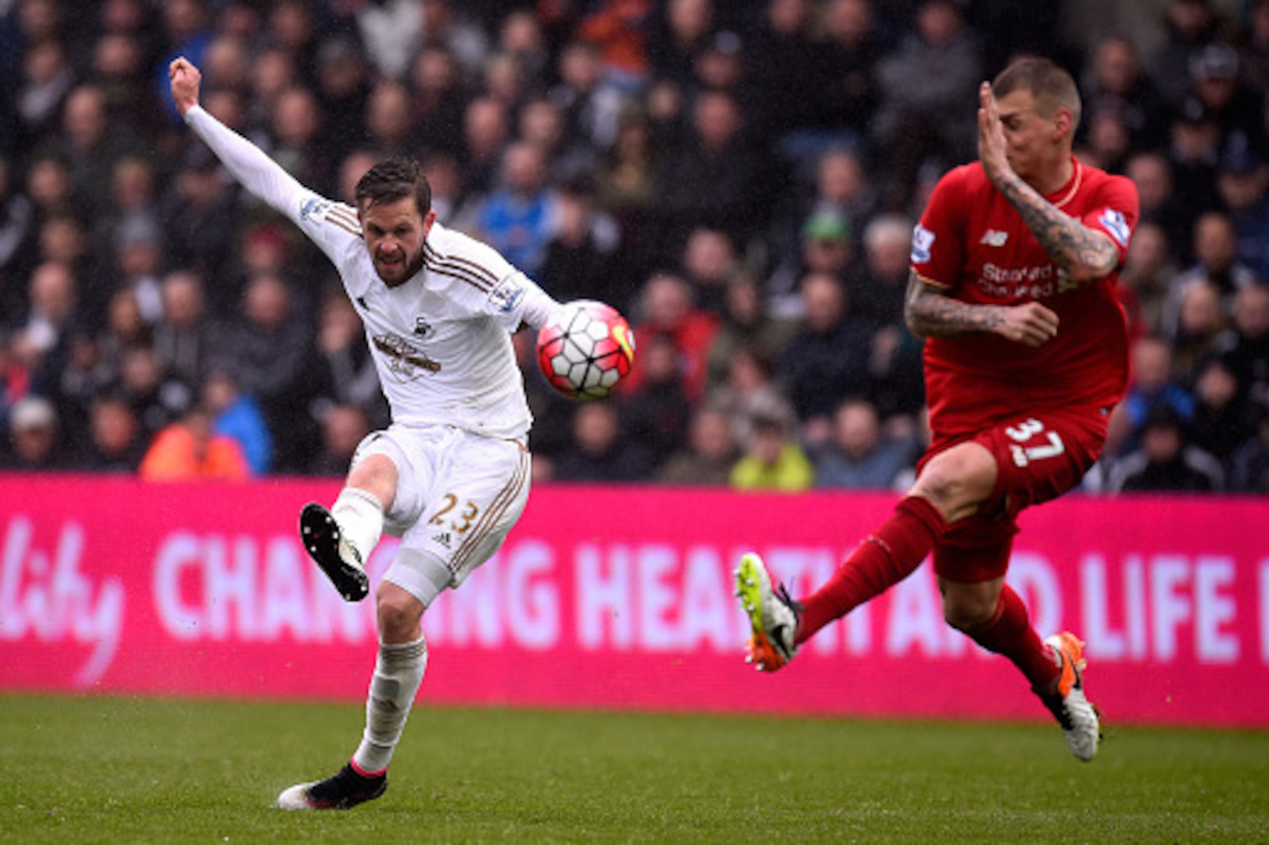 SWANSEA, WALES - MAY 01:  Swansea City player Gylfi Sigurdsson gets in a shot at goal despite the attentions of Martin Skrtel during the Barclays Premier League match between Swansea City and Liverpool at The Liberty Stadium on May 1, 2016 in Swansea, Wal