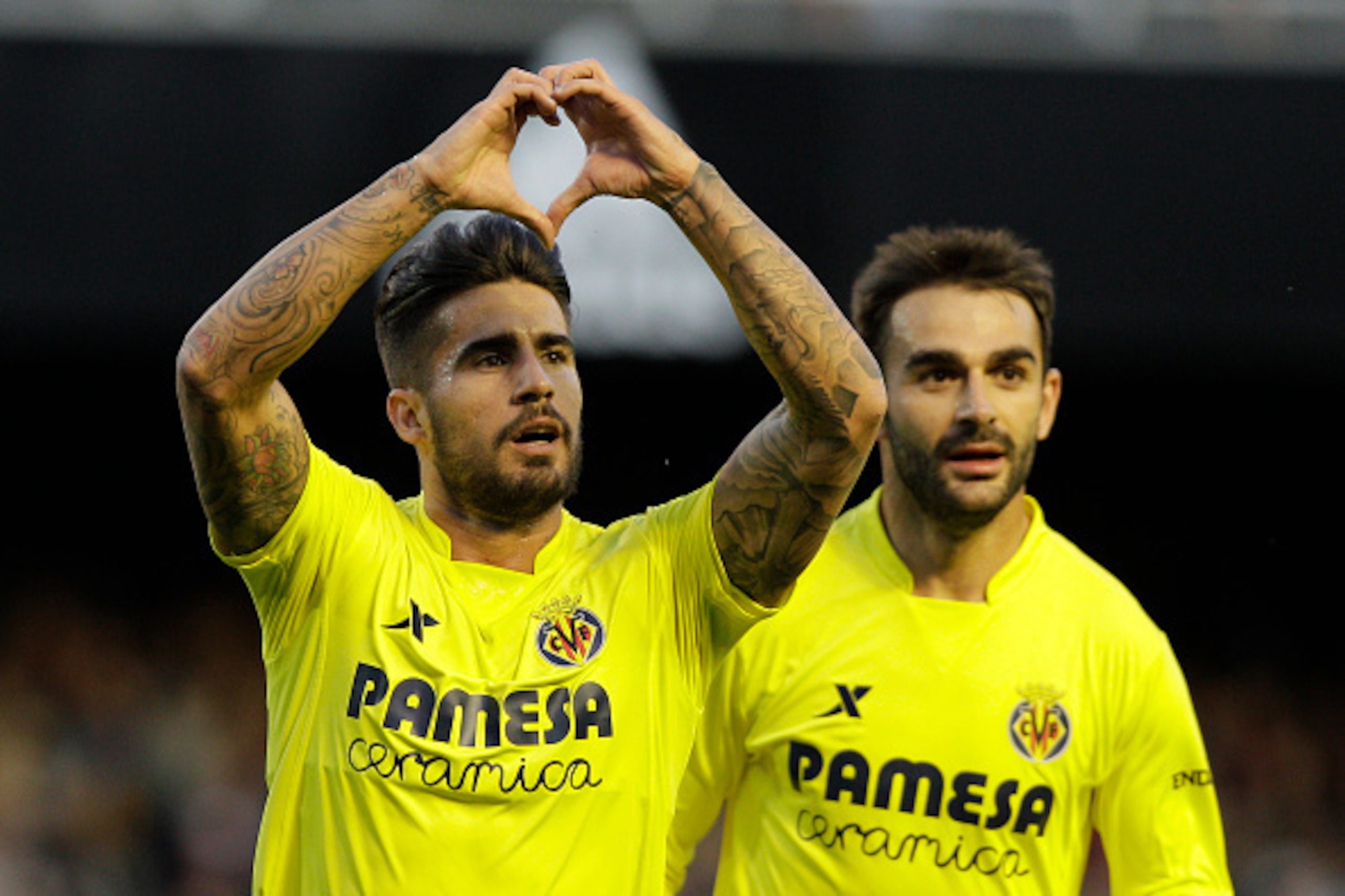 Villarreal's midfielder Samuel Garcia (L) celebrates past Villarreal's forward Adrian Lopez after scoring during the Spanish league football match Valencia CF vs Villarreal CF at the Mestalla stadium in Valencia on May 1, 2016. / AFP / JOSE JORDAN        