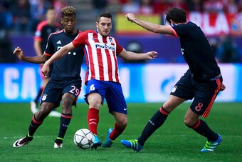 MADRID, SPAIN - APRIL 27: Koke (2ndL) of Atletico de Madrid competes for the ball with Kingsley Coman and Javi Martinez (R)  of Bayern Munich during the UEFA Champions League Semi Final first leg match between Club Atletico de Madrid and FC Bayern Muenche