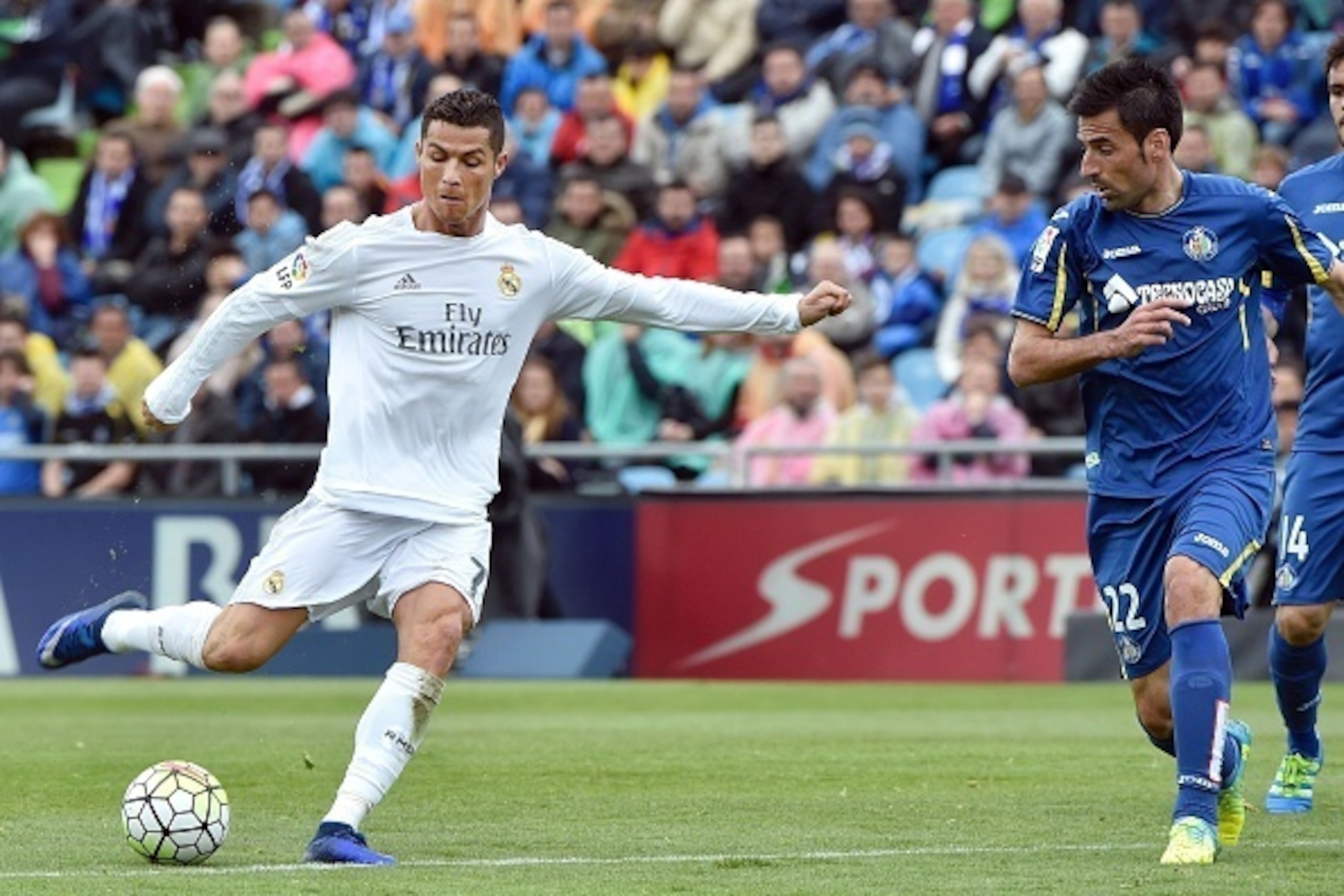 Real Madrid's Portuguese forward Cristiano Ronaldo (L) kicks a ball beside Getafe's midfielder Juan Rodriguez during the Spanish league football match Getafe CF vs Real Madrid CF at the Coliseum Alfonso Perez stadium in Getafe on April 16, 2016. Real Madr