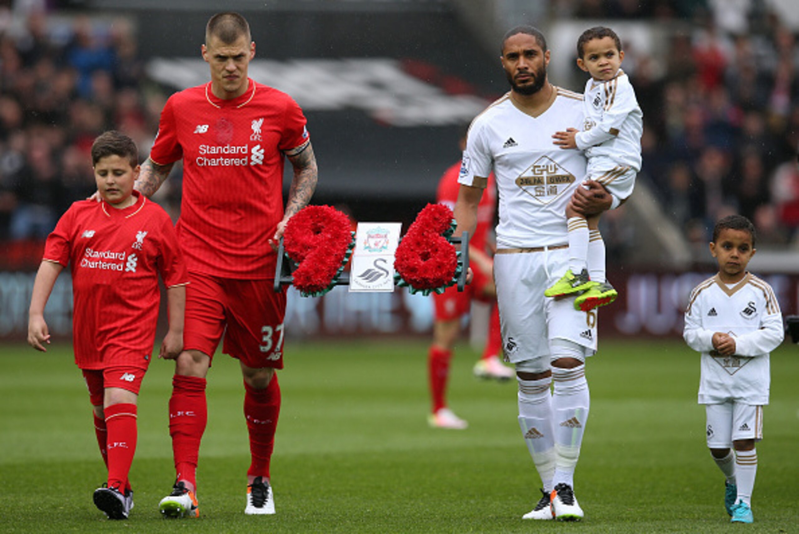 SWANSEA, WALES - MAY 01: Martin Skrtel of Liverpool and Ashley Williams of Swansea City carry a wreath as they remember the 96 victims of the Hillsborough disaster during the Barclays Premier League match between Swansea City and Liverpool at The Liberty 
