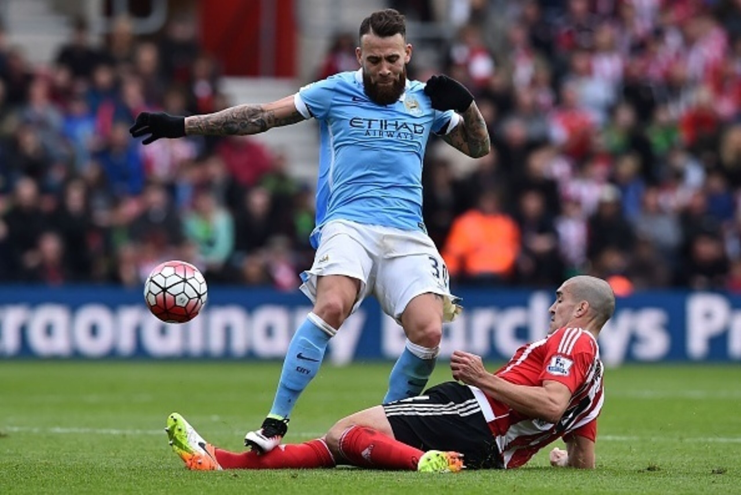Manchester City's Argentinian defender Nicolas Otamendi (top) is tackled by Southampton's Sepanish midfielder Oriol Romeu during the English Premier League football match between Southampton and Manchester City at St Mary's Stadium in Southampton, souther