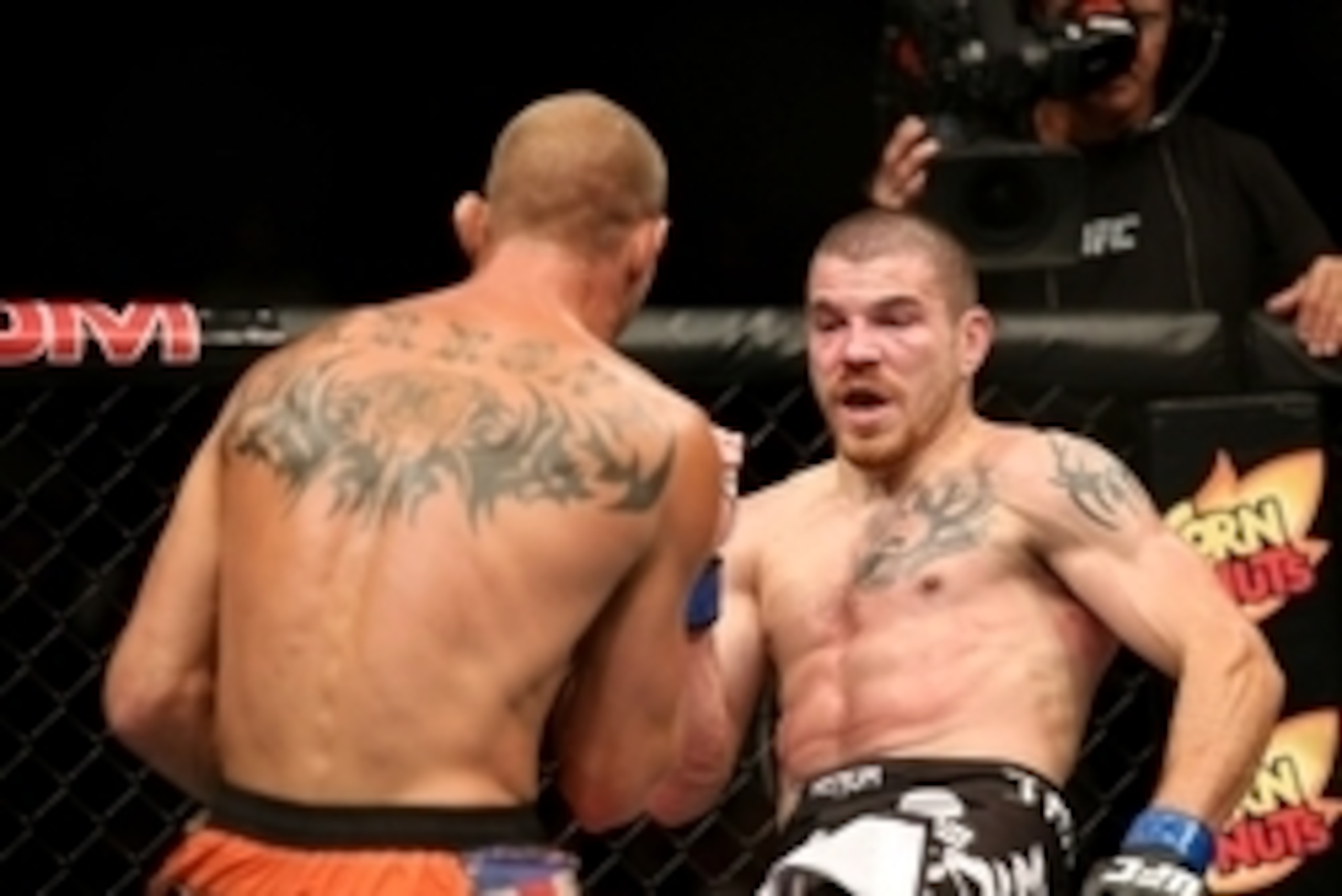 Jul 16, 2014; Atlantic City, NJ, USA; A bloodied Jim Miller (blue gloves) kicks at Donald Cerrone (red gloves) during a 5-round lightweight bout at Revel Casino. Mandatory Credit: Bill Streicher-USA TODAY Sports