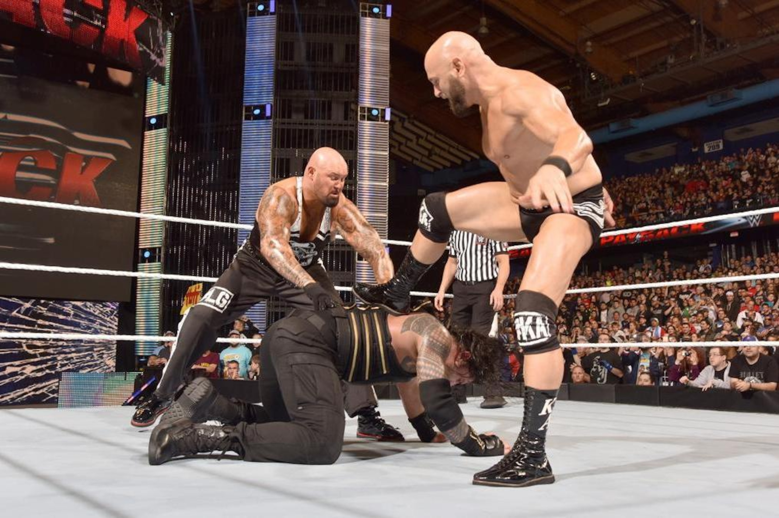 Luke Gallows and Karl Anderson go after Roman Reigns. AJ Styles is out of position to see this go down.