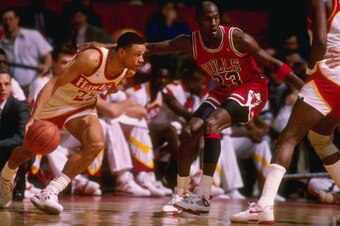 Guard Doc Rivers of the Atlanta Hawks tries to fend off guard Michael Jordan of the Chicago Bulls during a game at the Omni in Atlanta, Georgia.