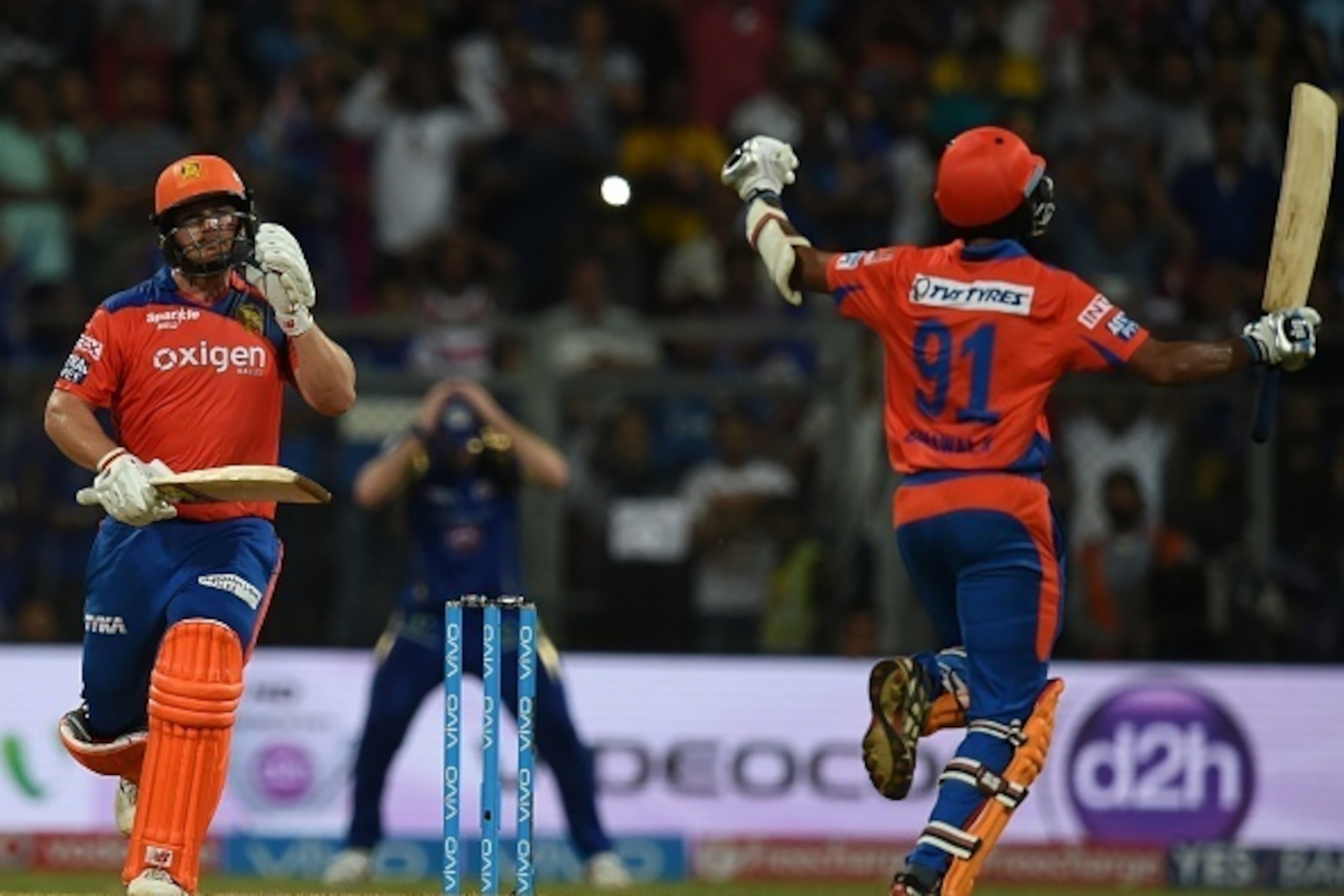 Gujarat Lions Aaron Finch (L) and Dhawal Kulkarni celebrate after the winning runs  during the 2016 Indian Premier League(IPL) Twenty20 cricket match between Gujarat Lions and Mumbai Indians at the Wankhede Stadium in Mumbai on April 16, 2016.  / AFP / IN