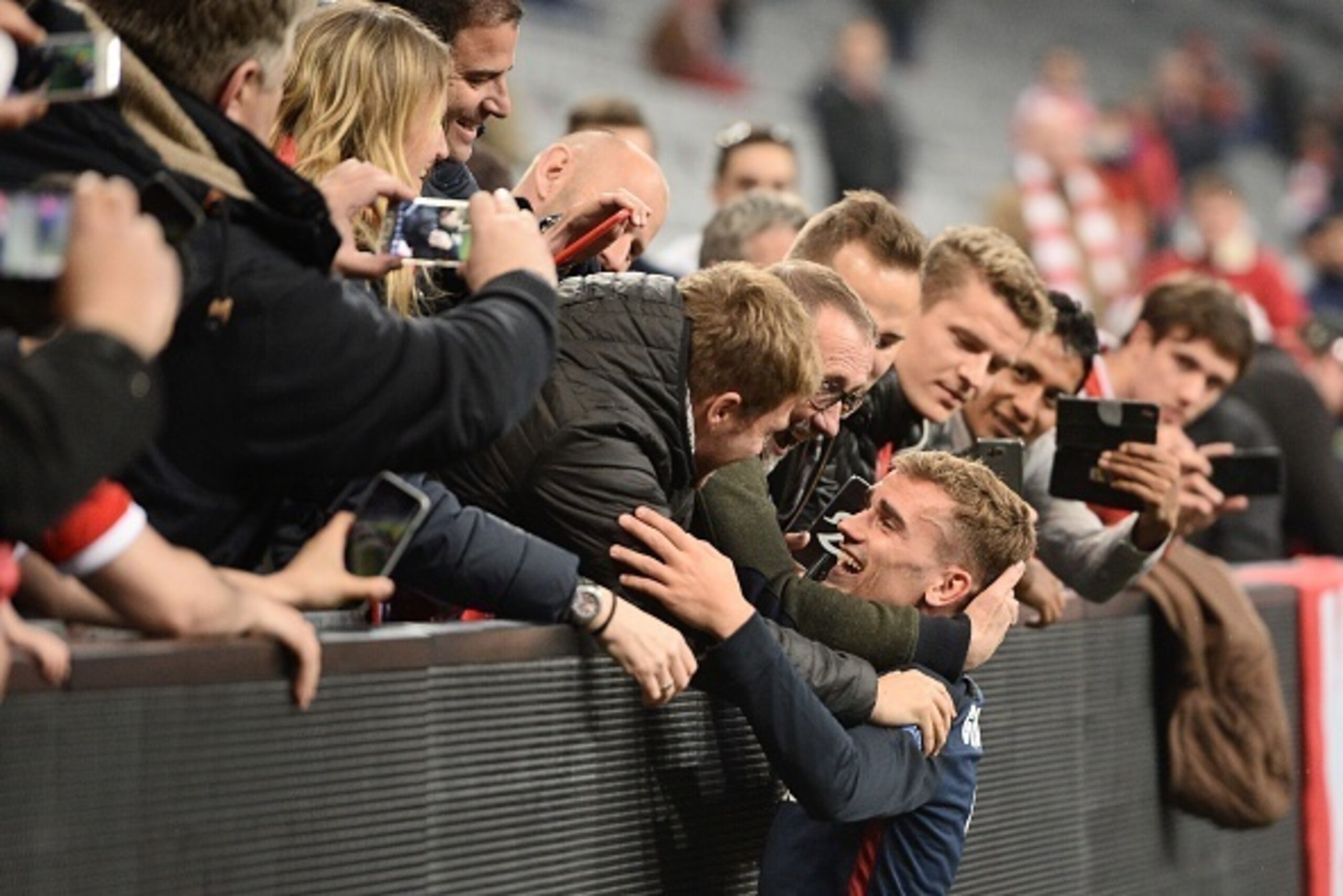 Atletico Madrid's French forward Antoine Griezmann is congratulated after the UEFA Champions League semi-final, second-leg football match between FC Bayern Munich and Atletico Madrid in Munich, southern Germany, on May 3, 2016. / AFP / LUKAS BARTH        