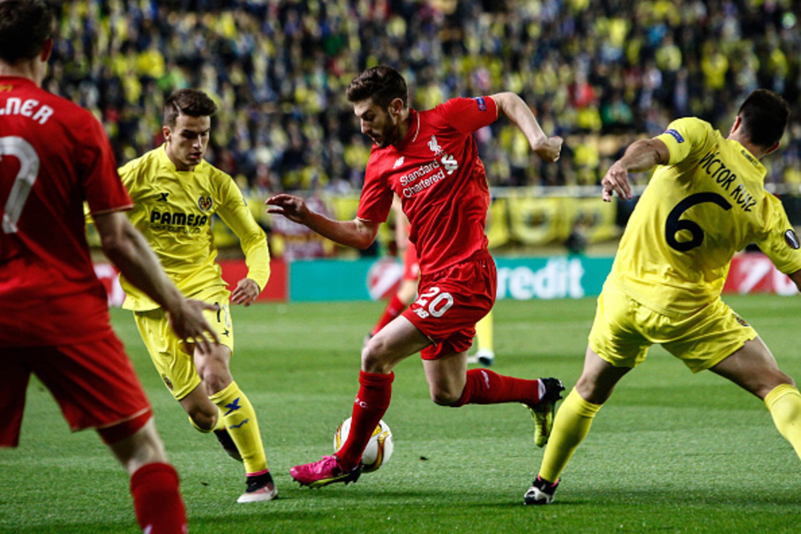 Liverpool's midfielder Adam Lallana (C) vies with Villarreal's Spanish defender Victor Ruiz (R) and Villarreal's defender Denis Suarez (L) during the UEFA Europa League semifinal first leg football match Villarreal CF vs Liverpool FC at El Madrigal stadiu