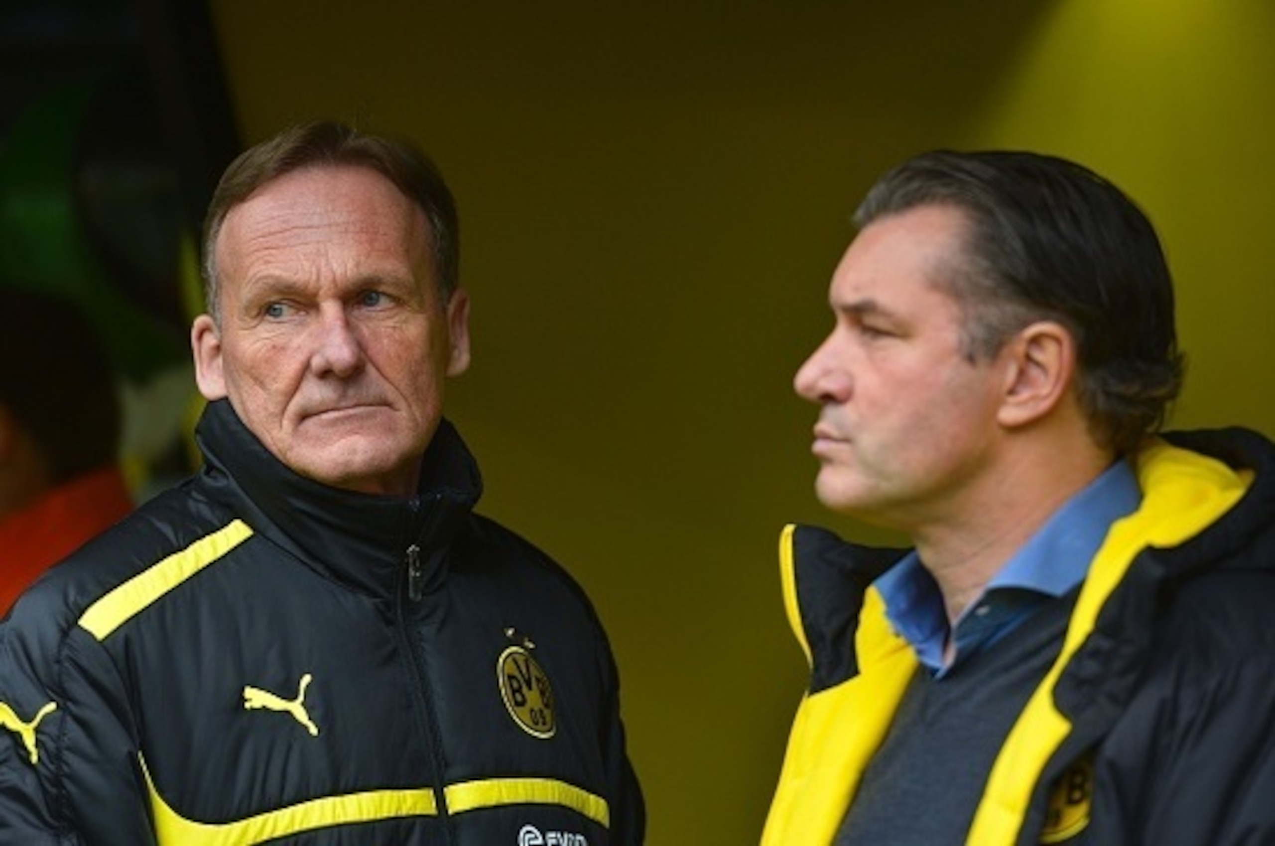 Dortmund's CEO Hans-Joachim Watzke (L) attends the German first division Bundesliga football match Borussia Dortmund vs VfL Wolfsburg, in Dortmund, western Germany, on April 30, 2016. / AFP / Sascha SCHï¿½ï¿½ï¿½ï¿½ï¿½ï¿½RMANN / RESTRICTIONS: DURING MATCH TIME: DFL RU
