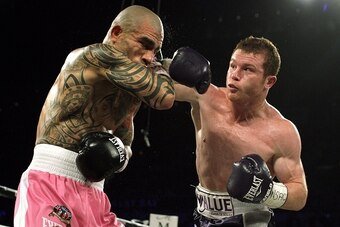 Miguel Cotto of Puerto Rico (L) absorbs a hard right from  Saul 'Canelo' Alvarez of  Mexico (R) during their middleweight championship boxing match on November 21, 2015 at the Mandalay Bay Events Center in Las Vegas, Nevada.  Alvarez captured the vacant W