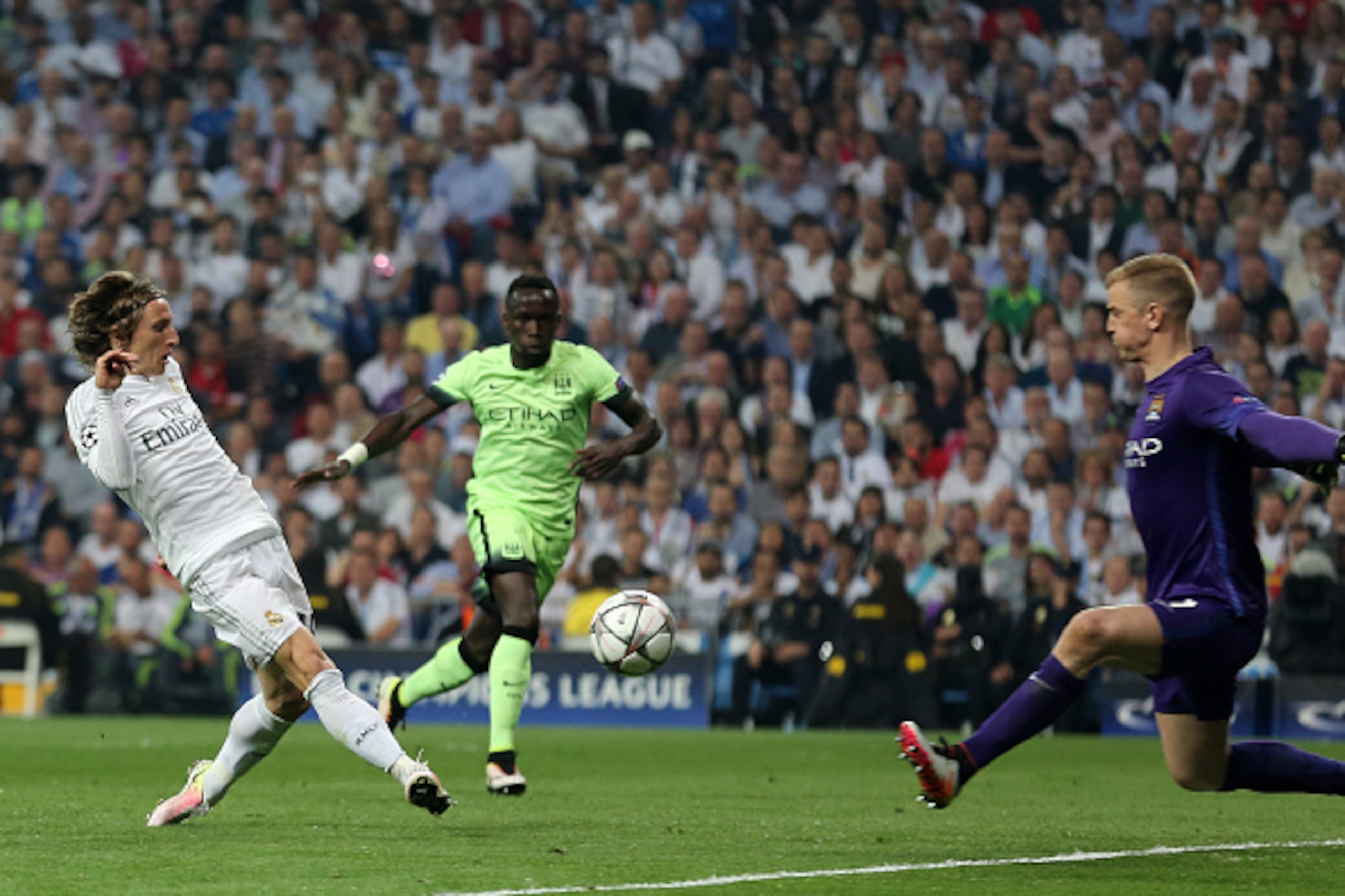 Real Madrid's Croatian midfielder Luka Modric (L) vies with Manchester City's goalkeeper Joe Hart (R) during the UEFA Champions League semi-final second leg football match Real Madrid CF vs Manchester City FC at the Santiago Bernabeu stadium in Madrid, on