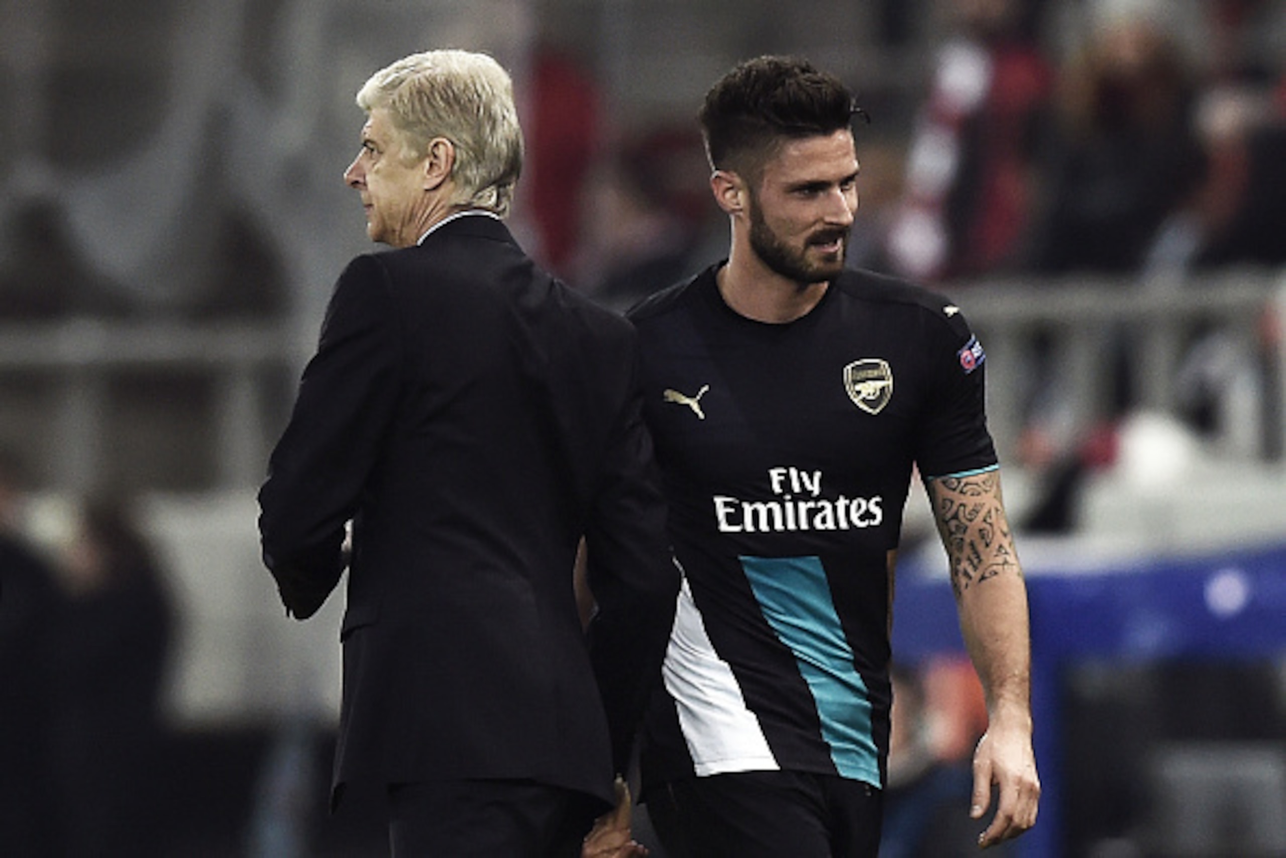 Arsenal's French forward Olivier Giroud (R) celebrates with Arsenal's French Coach Arsene Wenger  during the UEFA Champions League Group F football match between Olympiacos and Arsenal at the Georgios Karaiskakis Stadium in Piraeus near Athens on December
