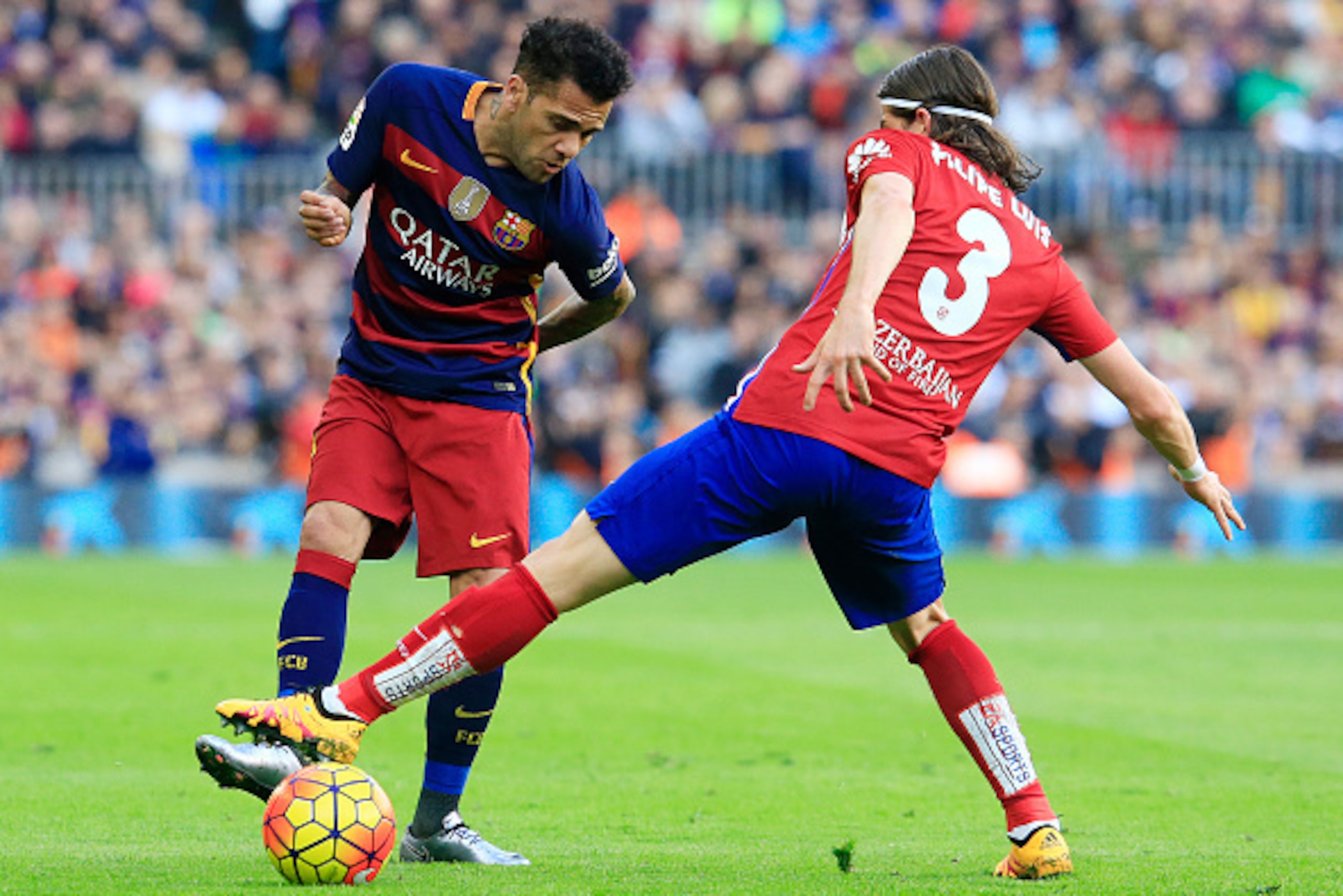 Barcelona's Brazilian defender Dani Alves (L) vies with Atletico Madrid's Brazilian defender Filipe Luis during the Spanish league football match FC Barcelona vs Club Atletico de Madrid at the Camp Nou stadium in Barcelona on January 30, 2016.   AFP PHOTO