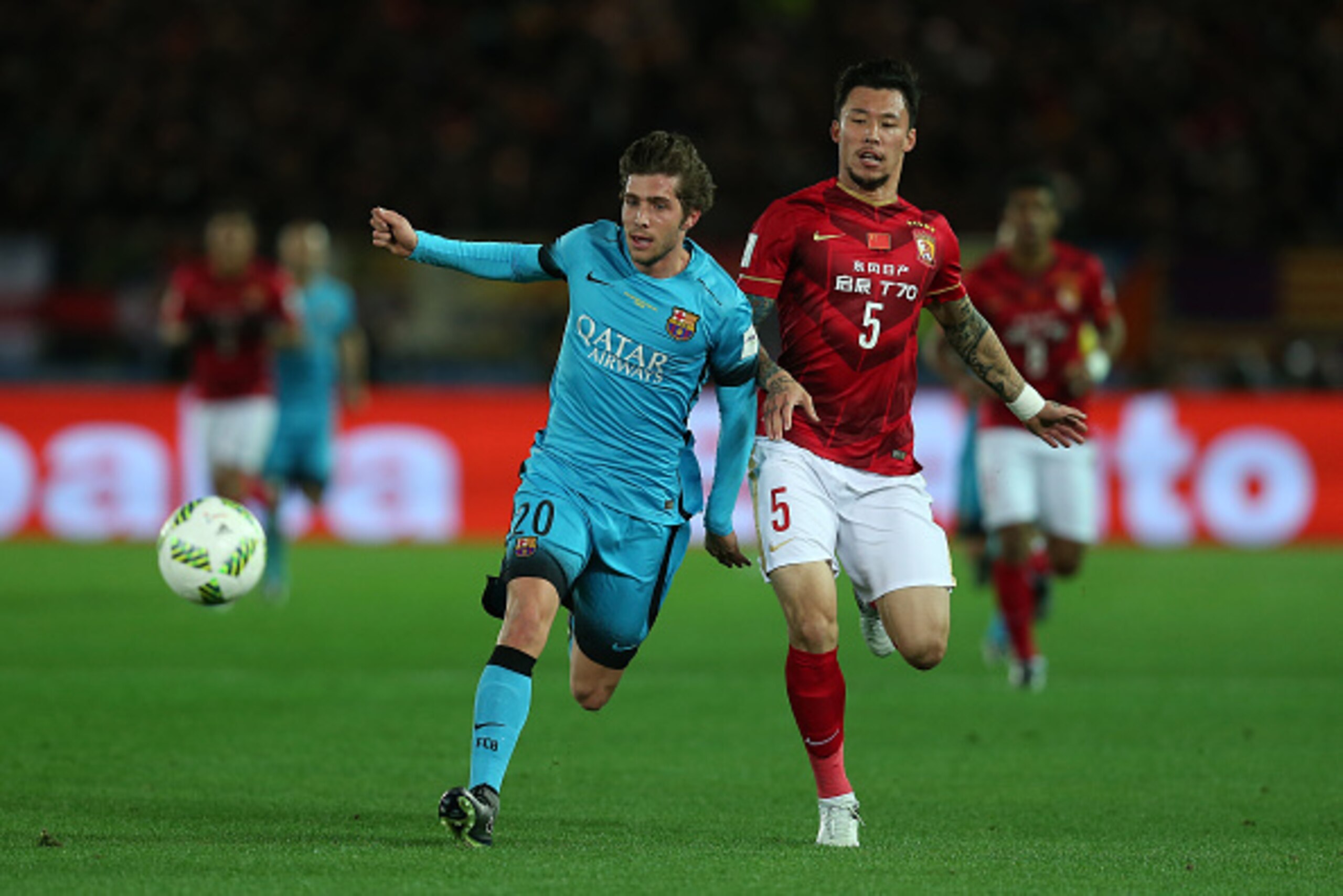 YOKOHAMA, JAPAN - DECEMBER 17: Sergi Roberto of Barcelona in action with Zhang Linpeng of Guangzhou Evergrande FC during the FIFA Club World Cup Semi Final match between Barcelona and Guangzhou Evergrande FC at the International Stadium Yokohama on Decemb
