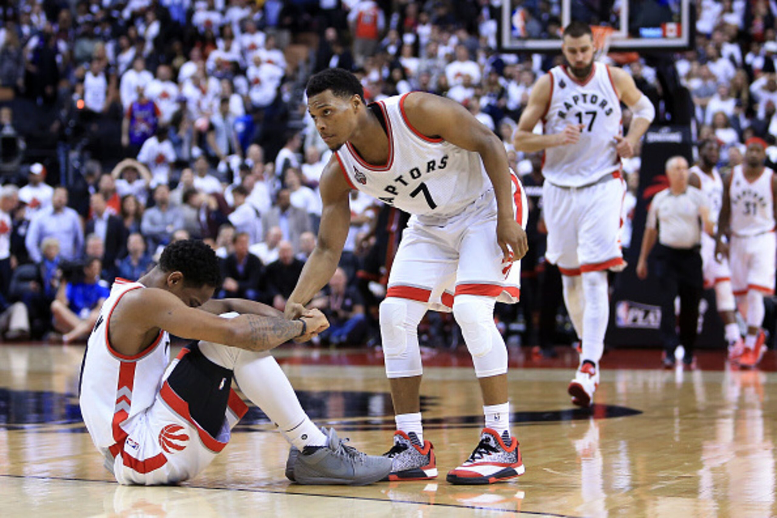 TORONTO, ON - MAY 03:  Kyle Lowry #7 of the Toronto Raptors attempts to help DeMar DeRozan #10 up off the floor late in the second half of Game One of the Eastern Conference Semifinals against the Miami Heat during the 2016 NBA Playoffs at the Air Canada 