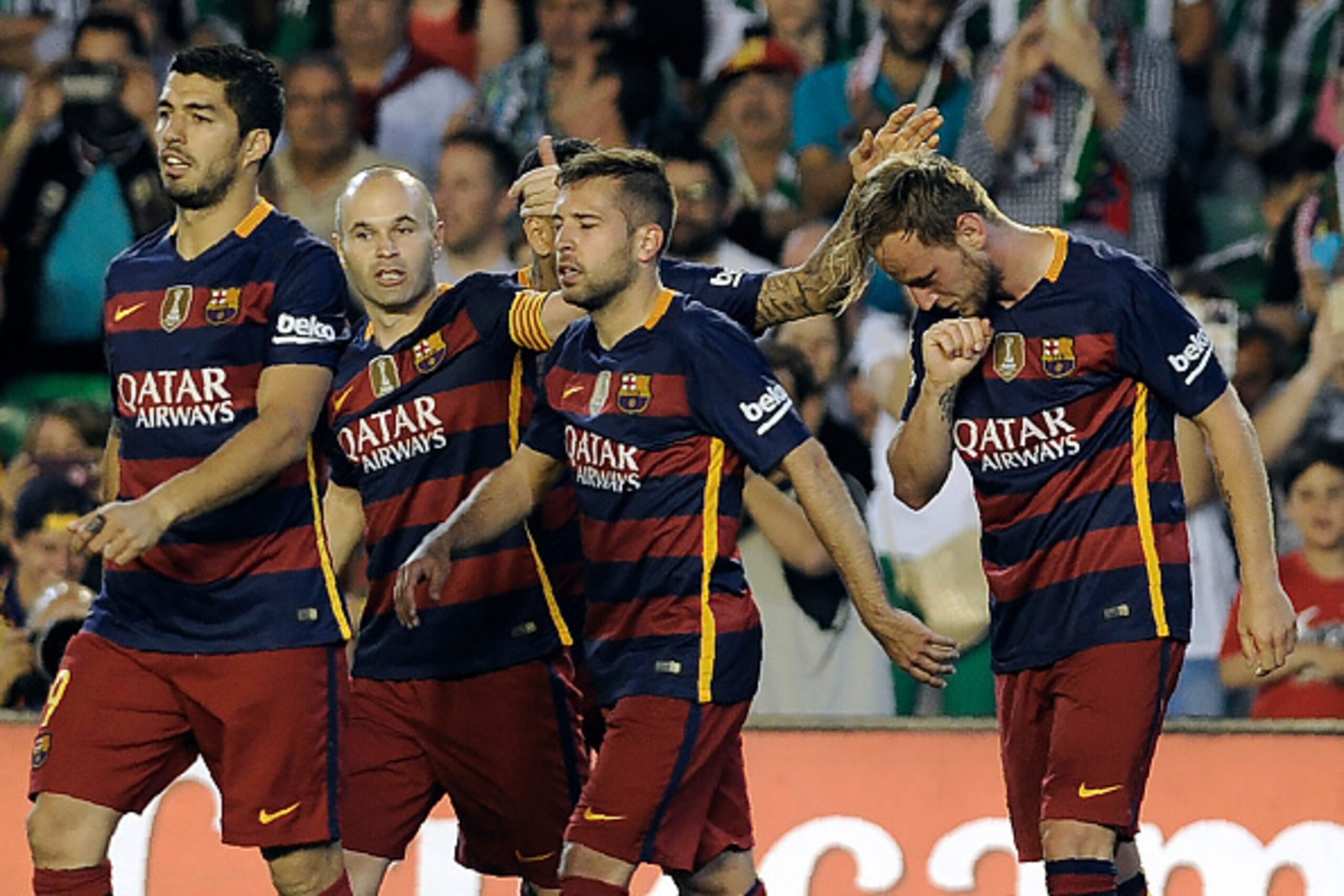 Barcelona's Uruguayan forward Luis Suarez (L) and Barcelona's midfielder Andres Iniesta (2nd L) walk with Barcelona's Croatian midfielder Ivan Rakitic (R) as he celebrates a goal during the Spanish league football match Real Betis Balompie vs FC Barcelona