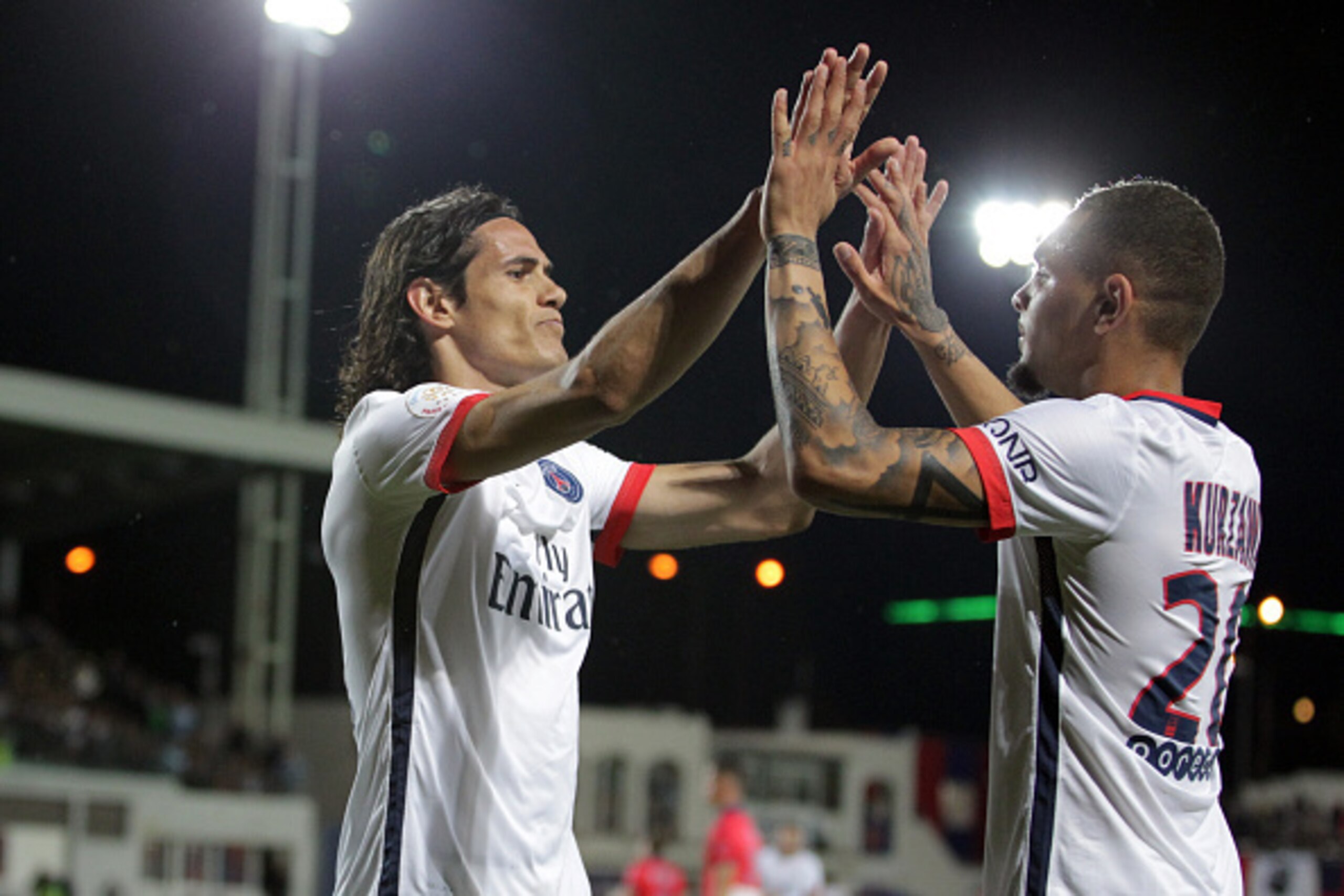 Paris Saint-Germain's Uruguayan forward Edinson Cavani (L) is congratulated by Paris Saint-Germain's French defender Layvin Kurzawa after scoring a goal during the L1 football match Gazelec Ajaccio (GFCA) against Paris Saint Germain (PSG) on May 7, 2016,