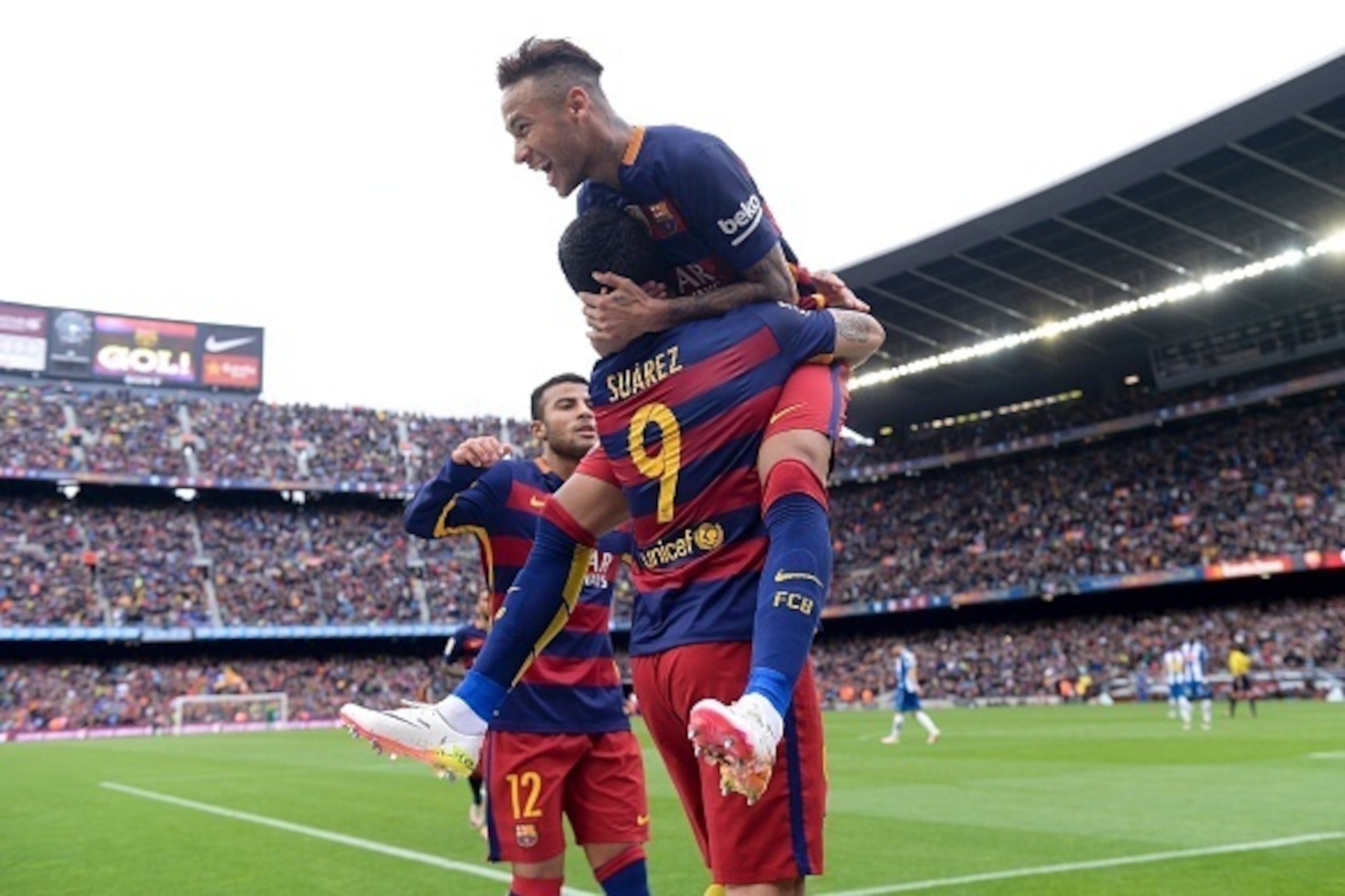 Barcelona's Brazilian forward Neymar (up) celebrates a goal with teammates Barcelona's Uruguayan forward Luis Suarez (down) and Barcelona's Brazilian midfielder Rafinha during the Spanish league football match FC Barcelona vs RCD Espanyol at the Camp Nou 
