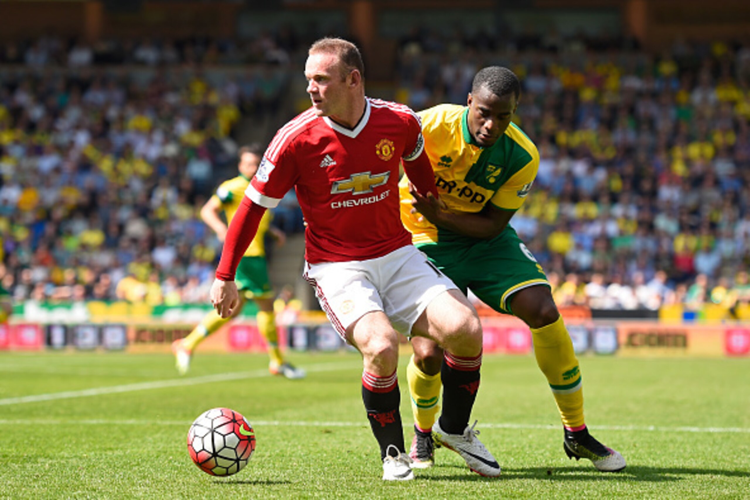 NORWICH, ENGLAND - MAY 07:  Wayne Rooney of Manchester United and Sebastien Bassong of Norwich City compete for the ball during the Barclays Premier League match between Norwich City and Manchester United at Carrow Road on May 7, 2016 in Norwich, England.