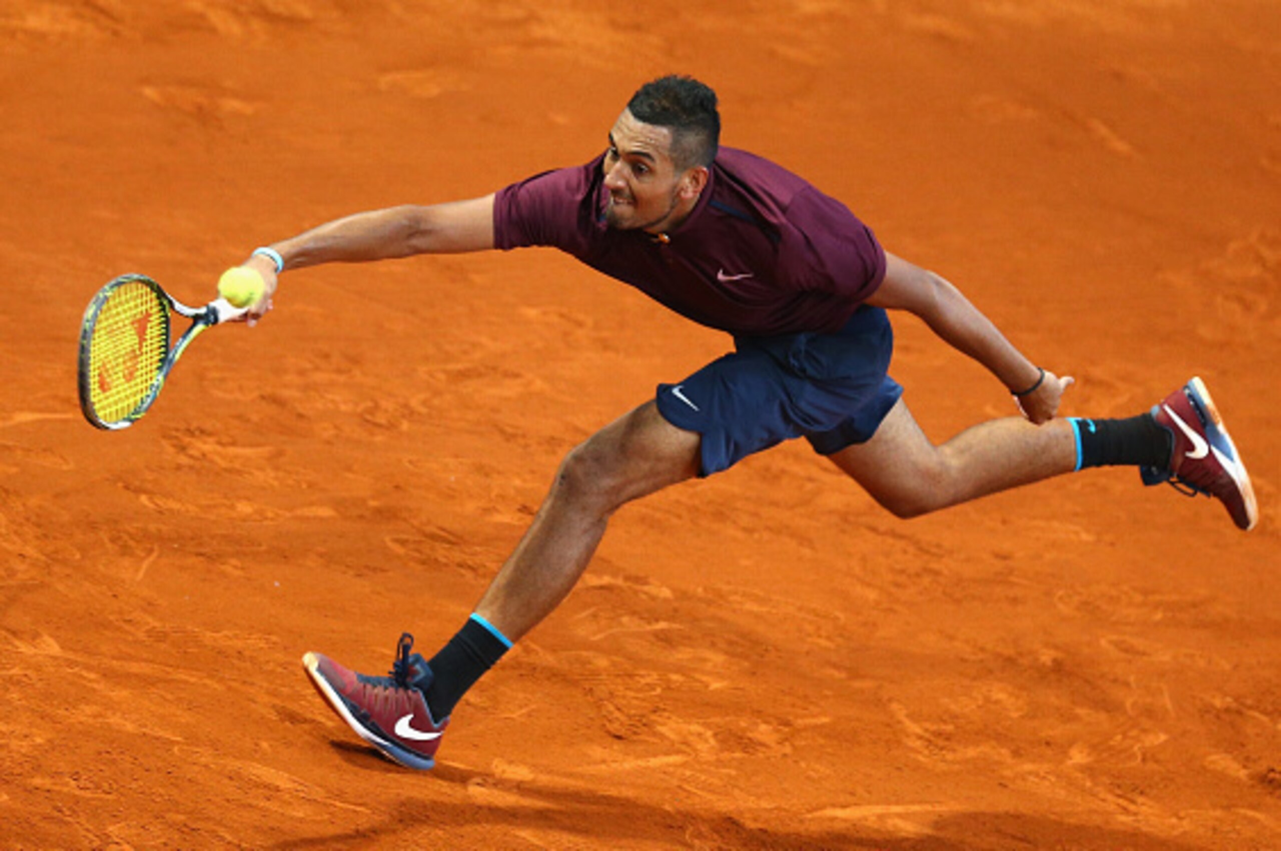 MADRID, SPAIN - MAY 06:  Nick Kyrgios of Australia stretches to play a forehand against Kei Nishikori of Japan in their quarter final round match during day seven of the Mutua Madrid Open tennis tournament at the Caja Magica  on May 06, 2016 in Madrid,Spa