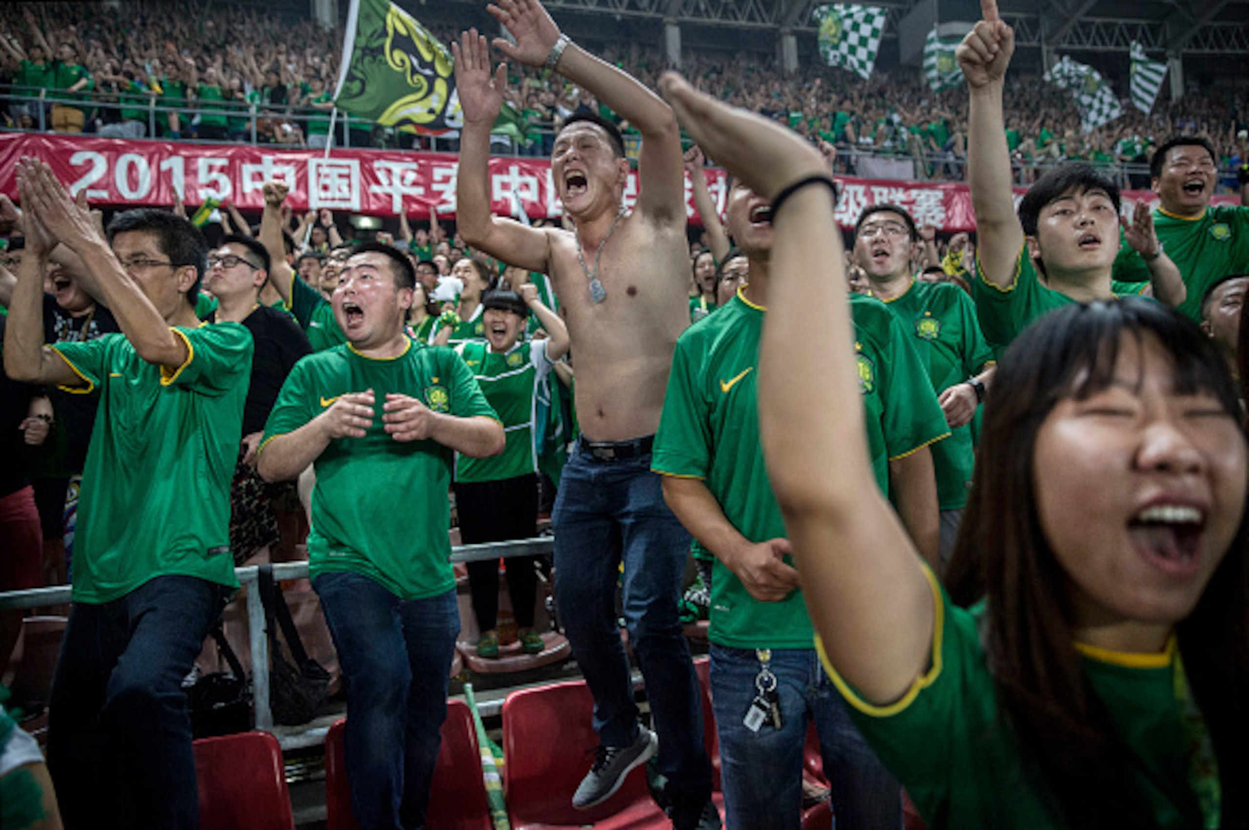 BEIJING, CHINA - JUNE 28: (CHINA OUT) Ultra supporters and fans of the Beijing Guoan FC celebrate together after a goal against Chongcing Lifan FC during their Chinese Super League match on June 28, 2015 in Beijing, China. There are growing legions of ard BEIJING, CHINA - JUNE 28: (CHINA OUT) Ultra supporters and fans of the Beijing Guoan FC celebrate together after a goal against Chongcing Lifan FC during their Chinese Super League match on June 28, 2015 in Beijing, China. There are growing legions of ard
