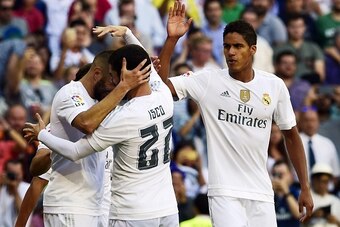 Real Madrid's French forward Karim Benzema (L) celebrates with Real Madrid's midfielder Isco (C) and Real Madrid's French defender Raphael Varane after scoring a goal during the Spanish league football match Real Madrid CF vs Granada FC at the Santiago Be
