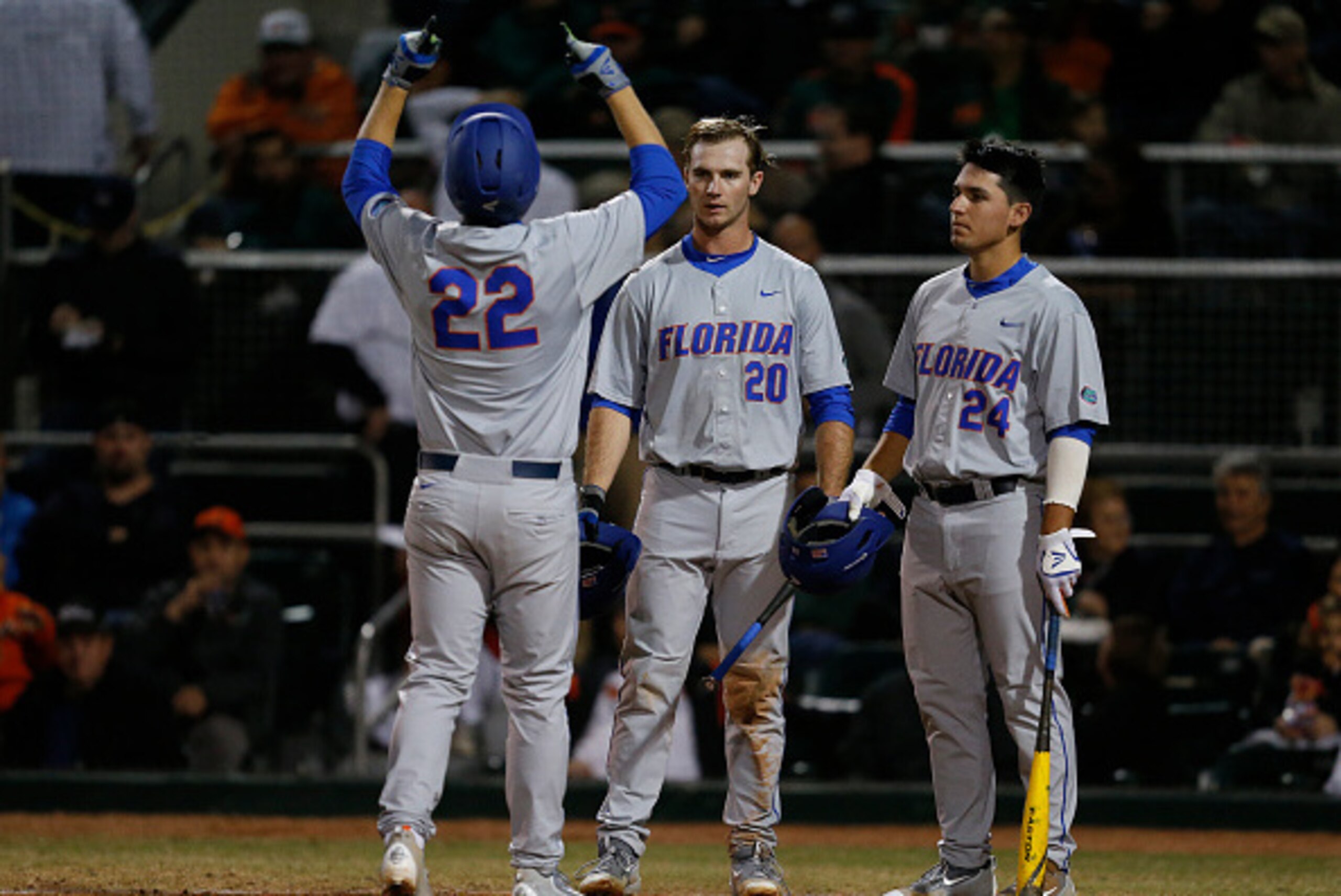 CORAL GABLES, FL - FEBRUARY 26: JJ Schwarz #22 is congratulated by Peter Alonso #20 and Jeremy Vasquez #24 of the Florida Gators after hitting a solo home run against the Miami Hurricanes on February 26, 2016 at Alex Rodriguez Park at Mark Light Field in 